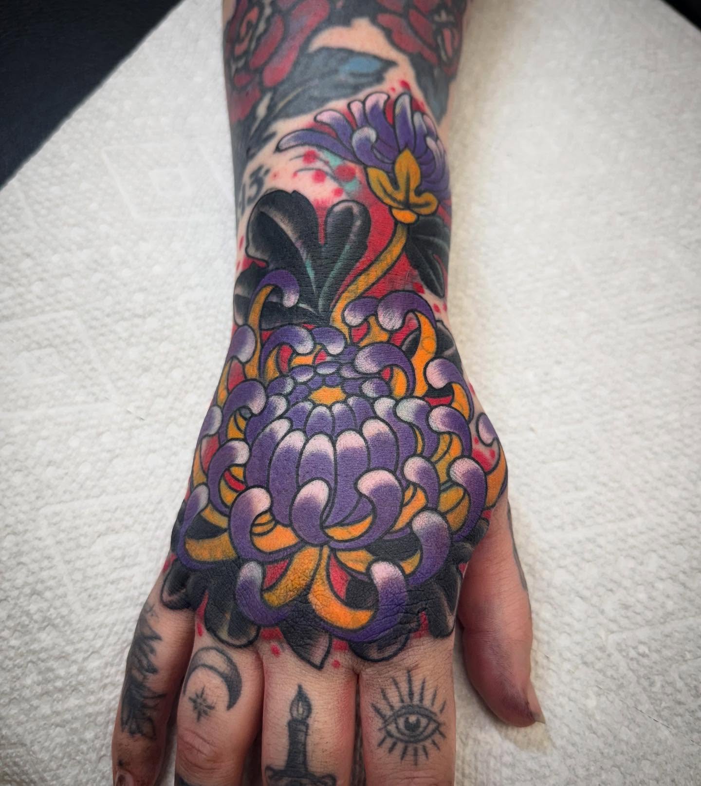 Chrysanthemum American traditional tattoo on the hand by Ethan Bennett