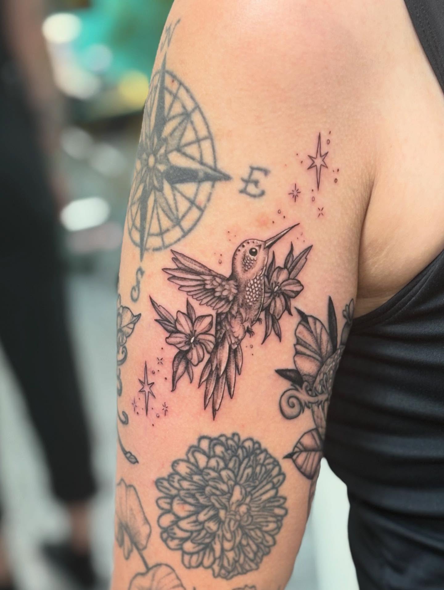 Hummingbird and flowers black and grey tattoo on the forearm by Jayda Shell