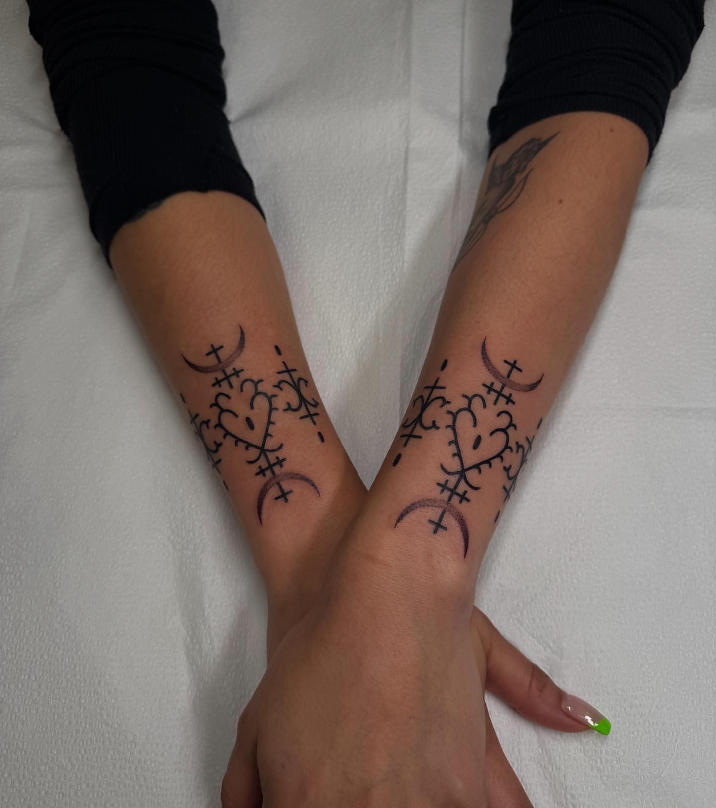 Crosses and crescents black and grey tattoo on the forearm by Erin Shea