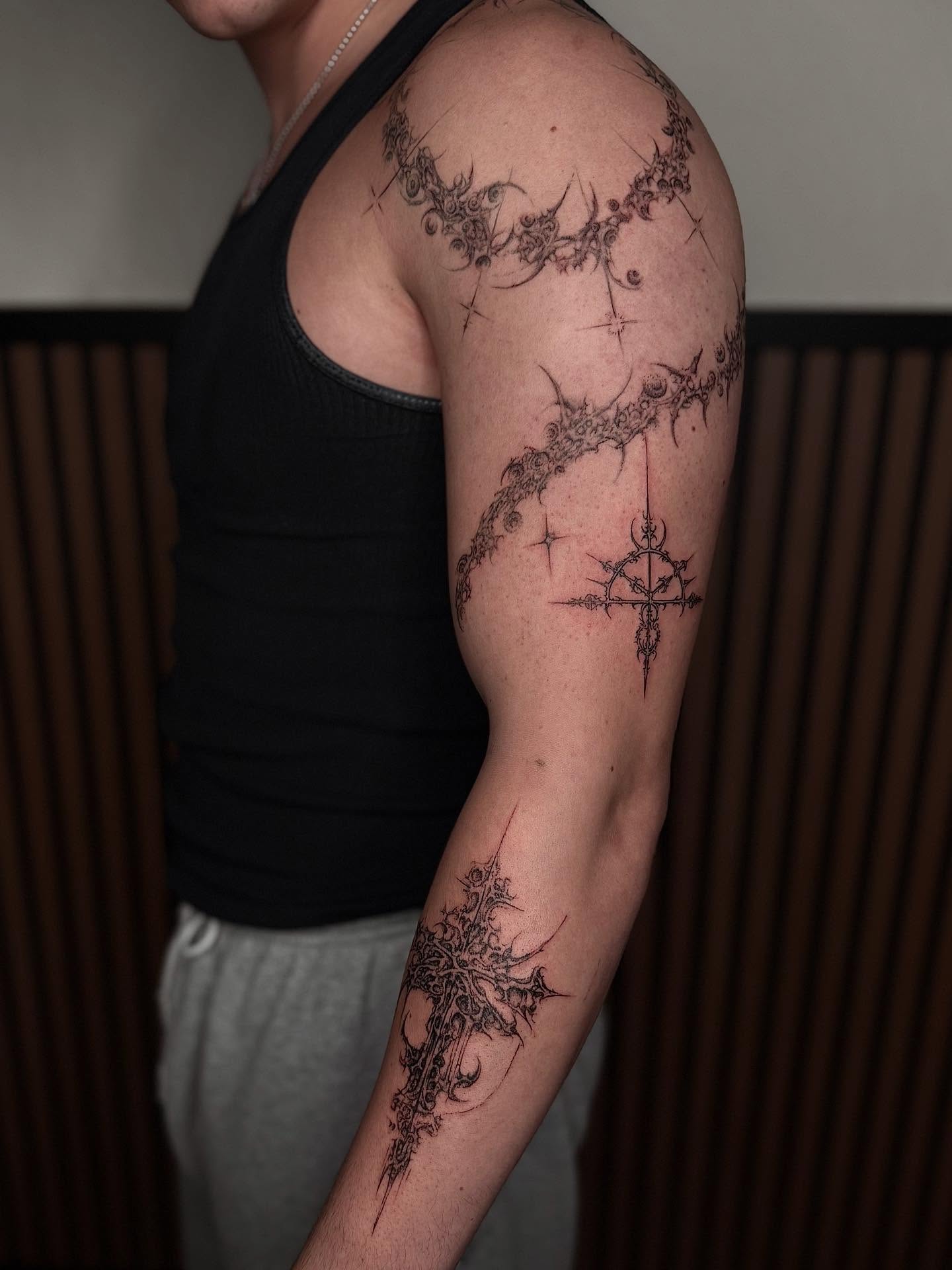 Cross geometric tattoo on the upper arm by Jocelyn