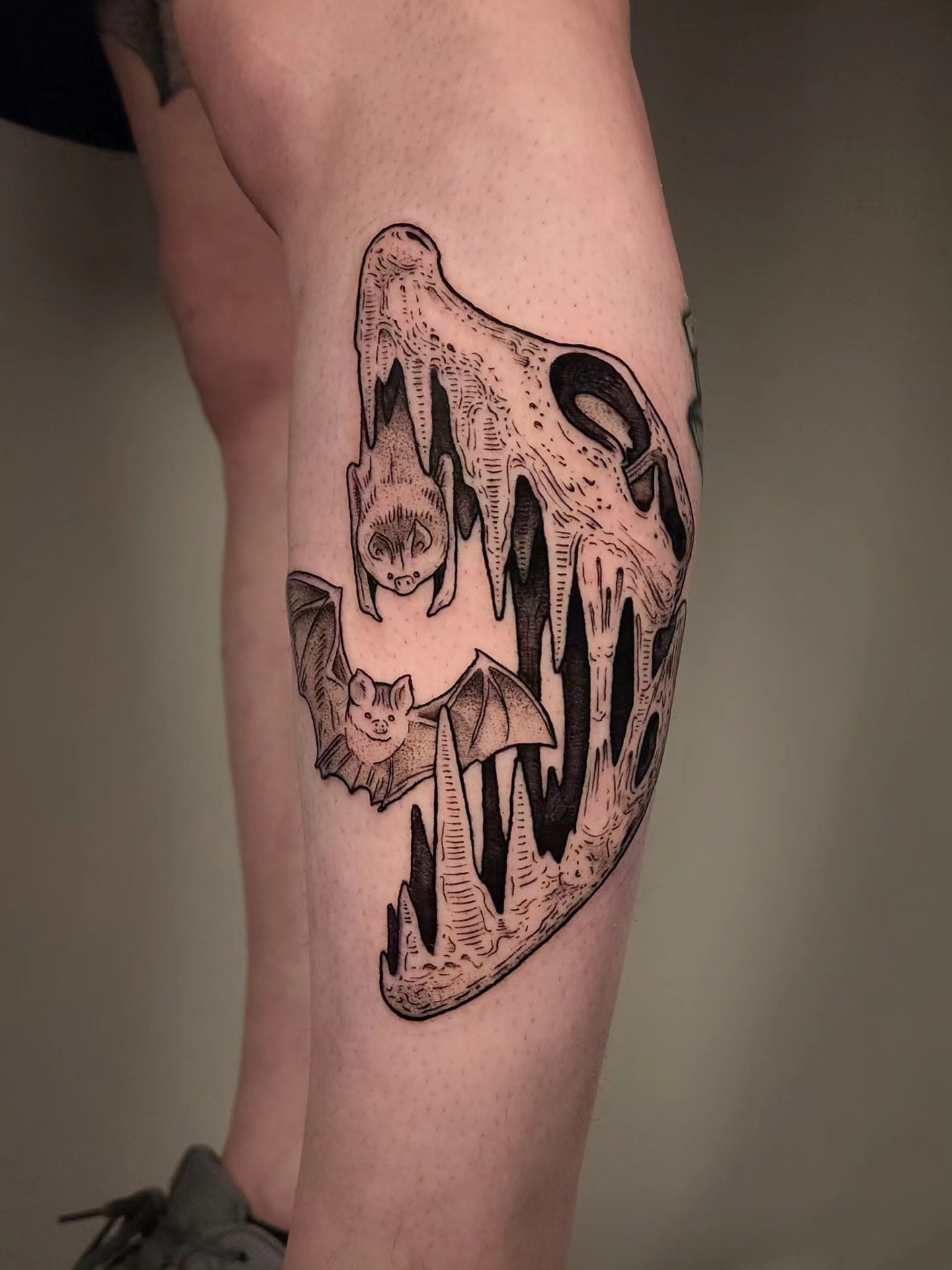 Bat skull black and grey tattoo on the leg by Whitney Caskey