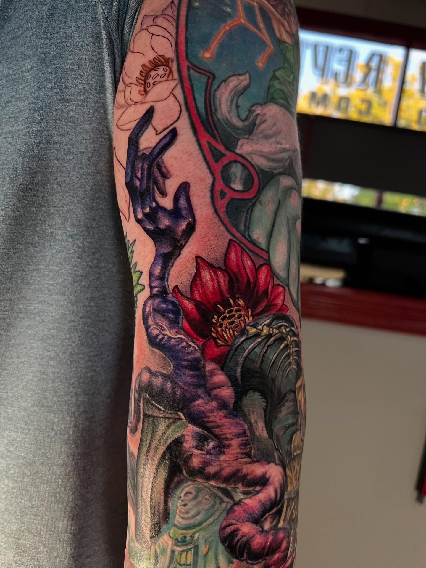 Lotus flower and tentacle realism tattoo on the forearm by Josh Green
