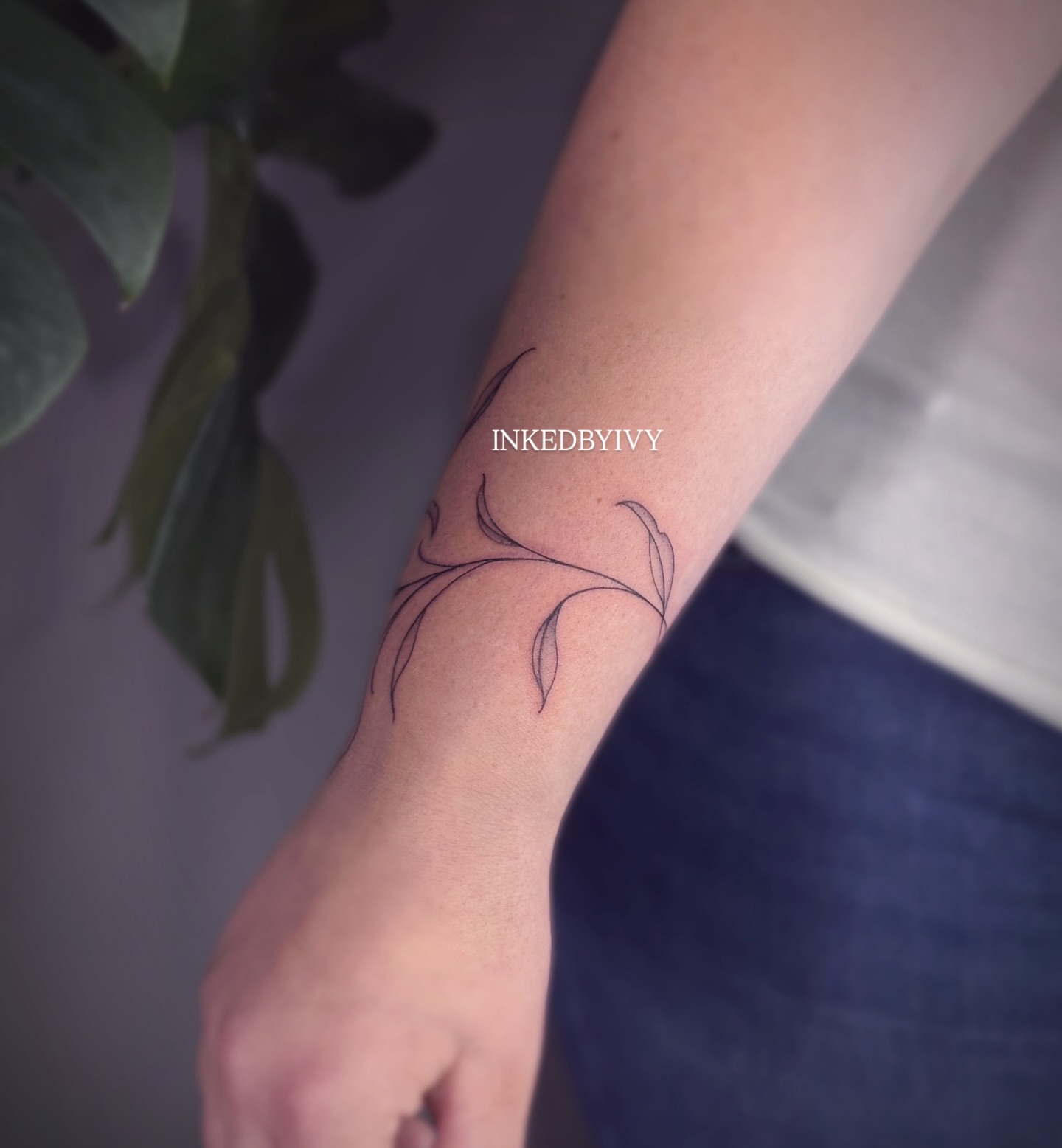 Branch with leaves fine line tattoo on the forearm by IVY