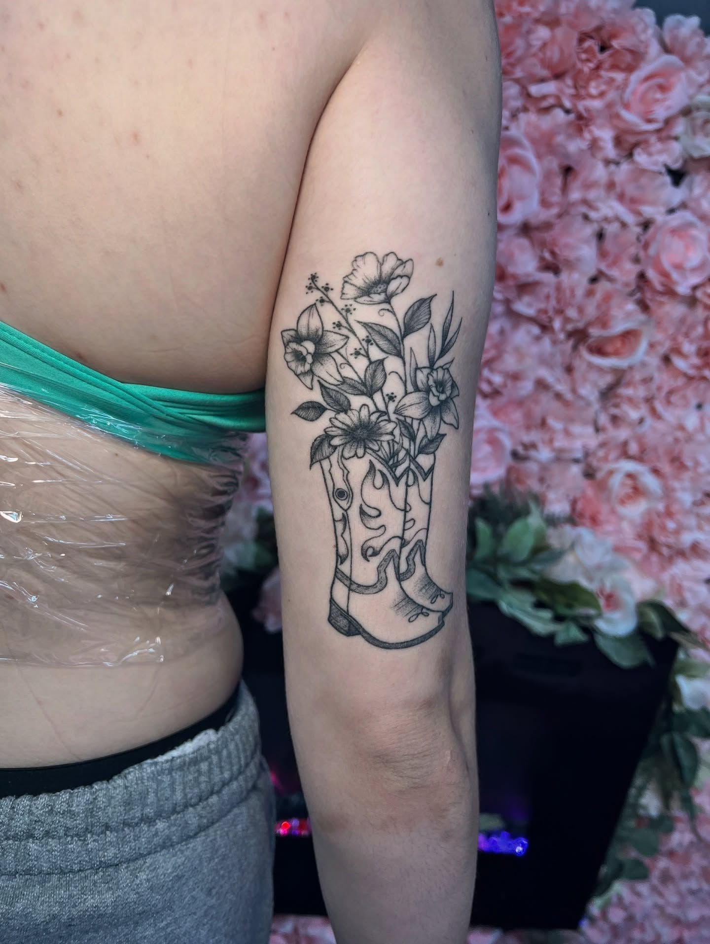 Cowboy boots and flowers black and grey tattoo on the forearm by 𝒱𝒽𝓎𝓍𝒾𝓃