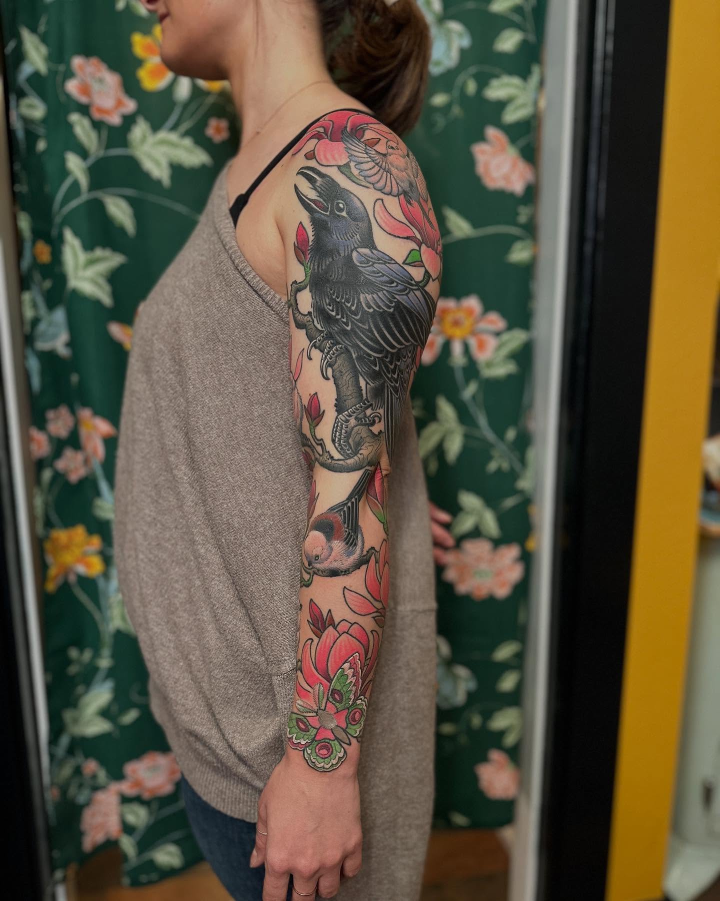 Crow and flowers American traditional tattoo on the upper arm by Megon Shore, Seattle, Washington