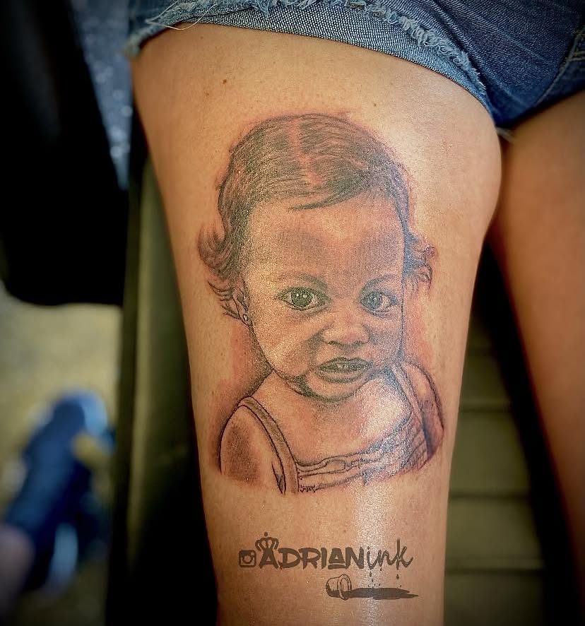 Baby portrait realism tattoo on the thigh by Adrian Shan Carr