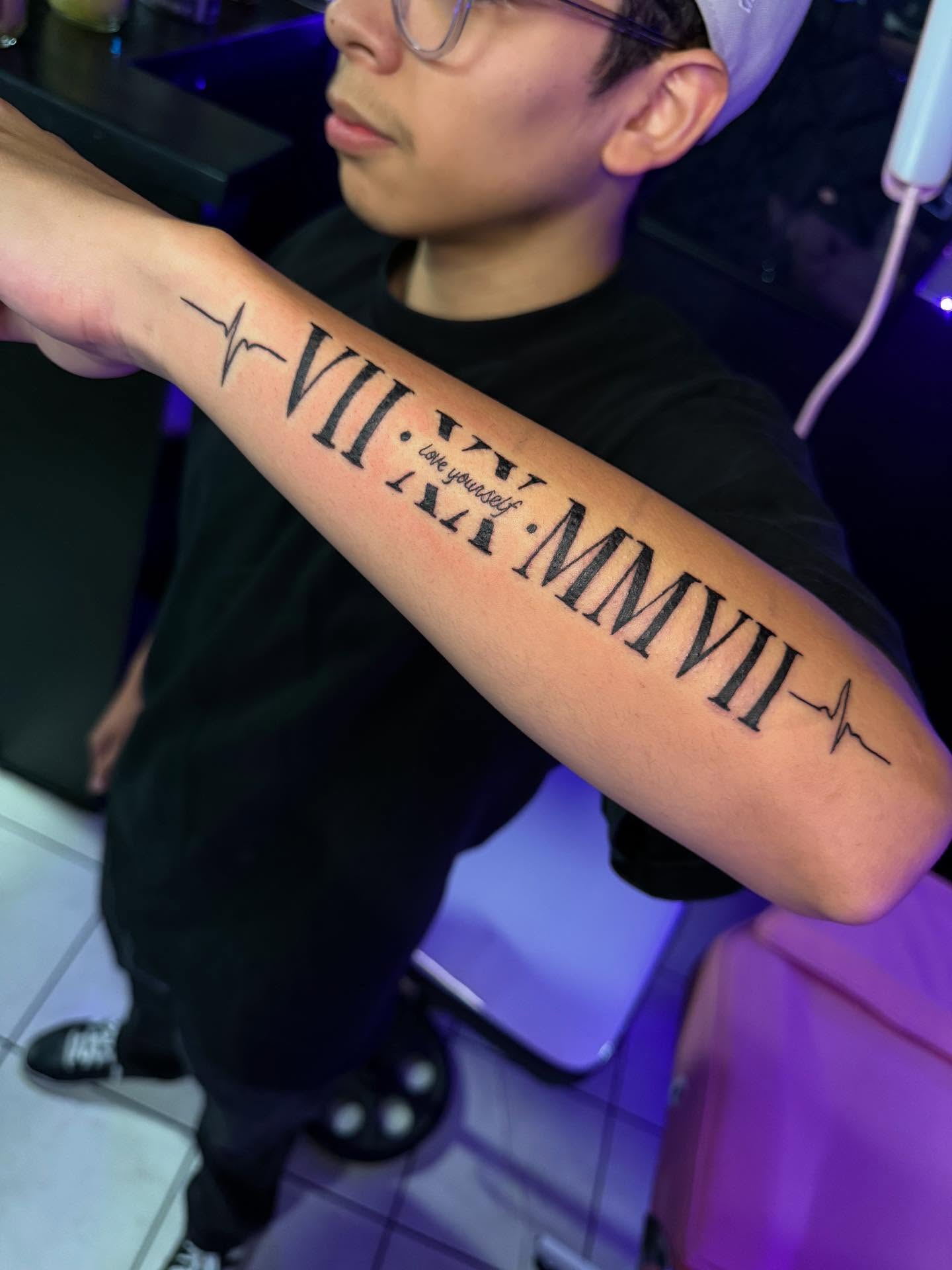 Roman numerals and heartbeat line lettering script tattoo on the forearm by Jasmin Lozano