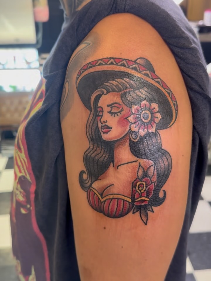 Woman wearing sombrero American traditional tattoo on the shoulder by Don Robison