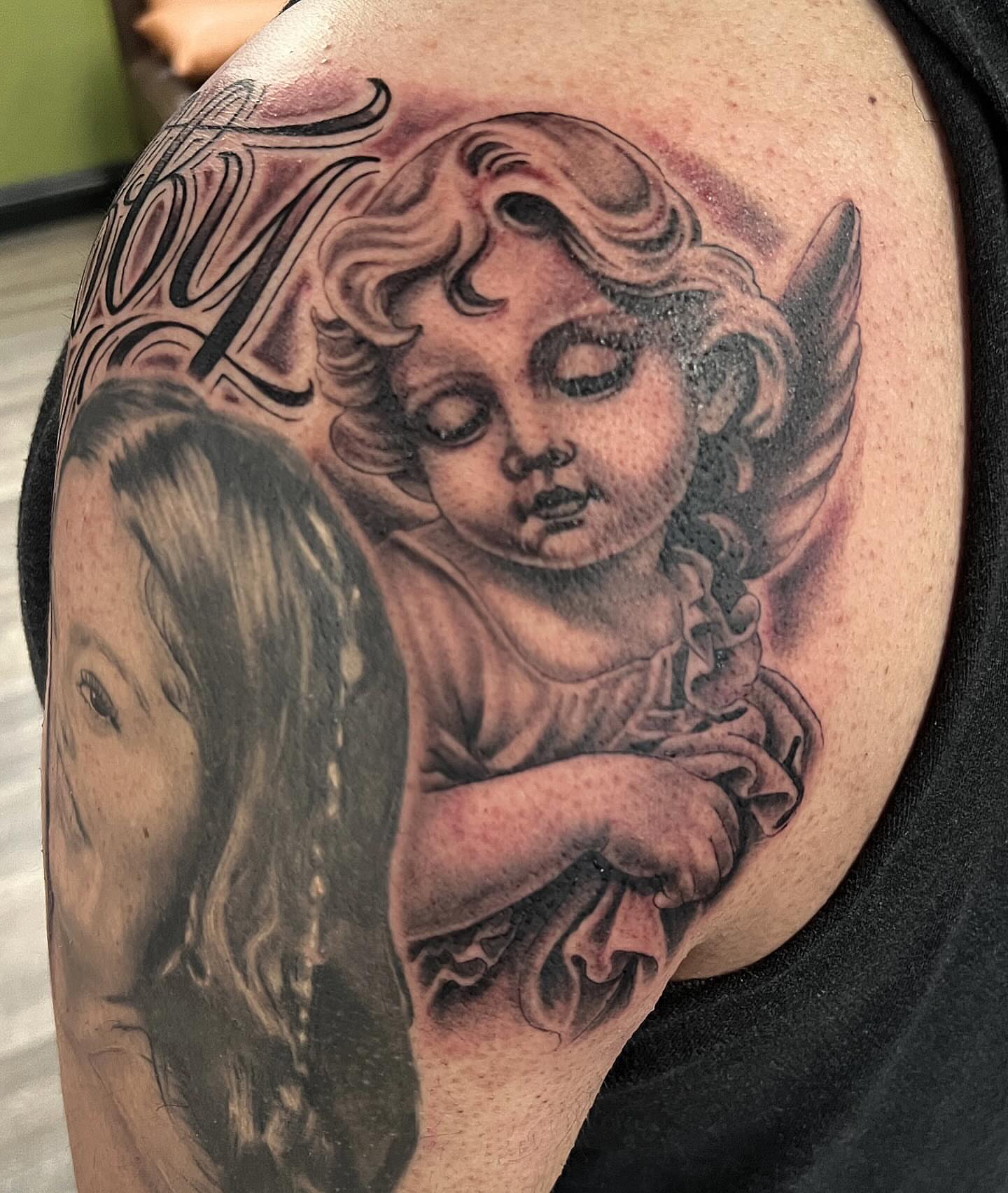 Cherub and woman realism tattoo on the shoulder by Niz Carrillo