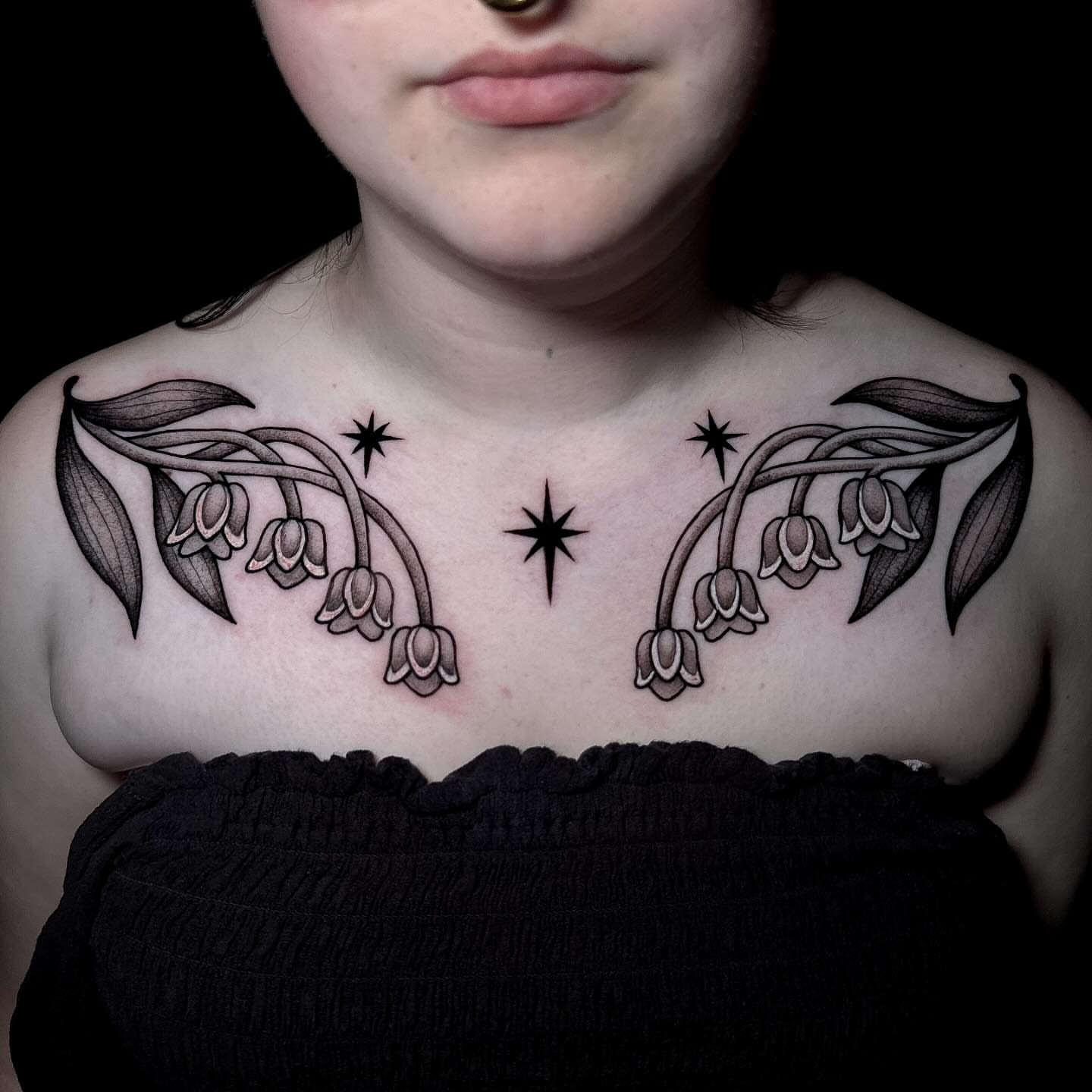 Lily of the valley black and grey tattoo on the chest by Amber