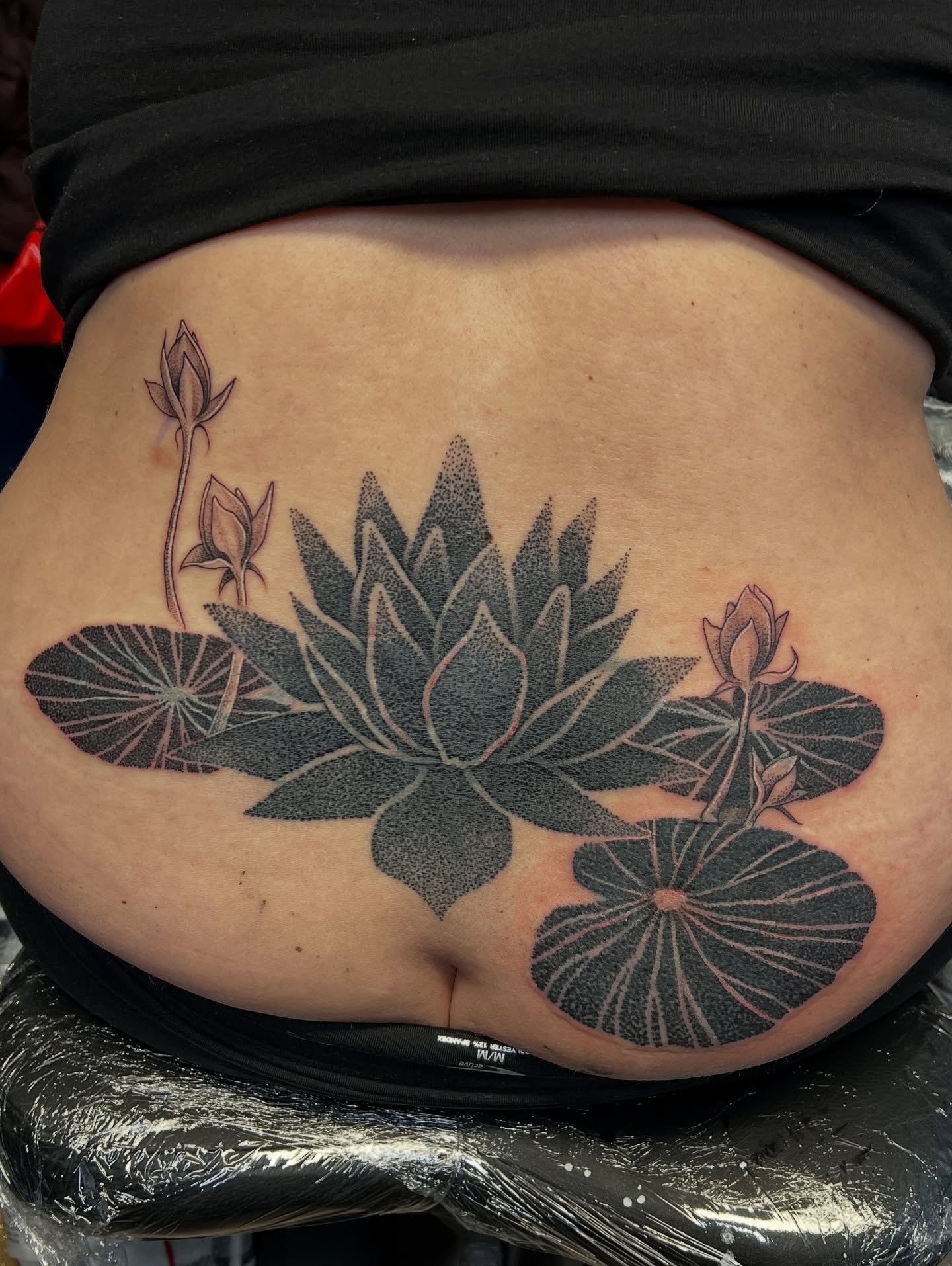 Lotus flower dotwork tattoo on the torso by Bombay Pain Co.