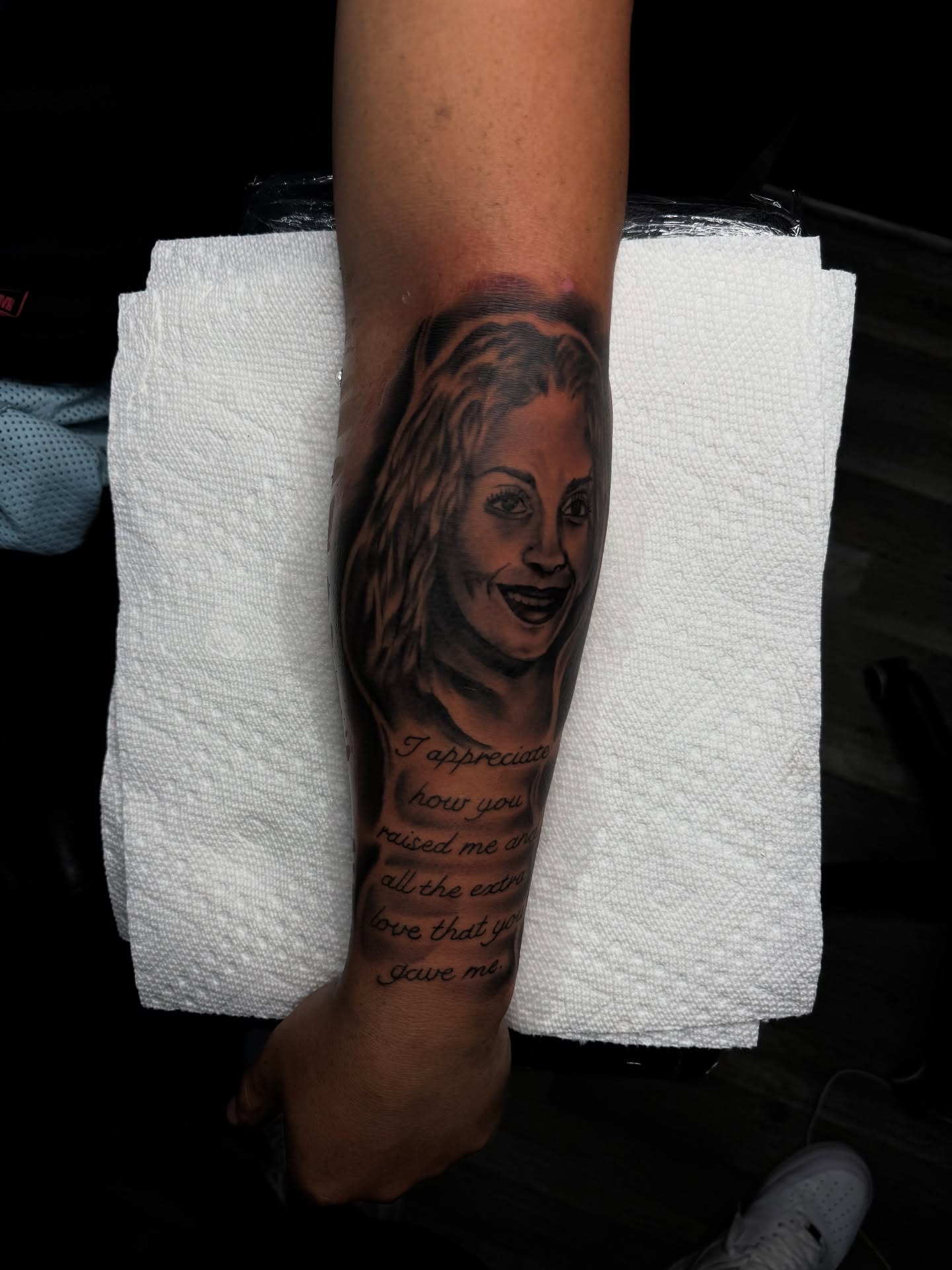 Portrait with quote realism tattoo on the forearm by Zeus