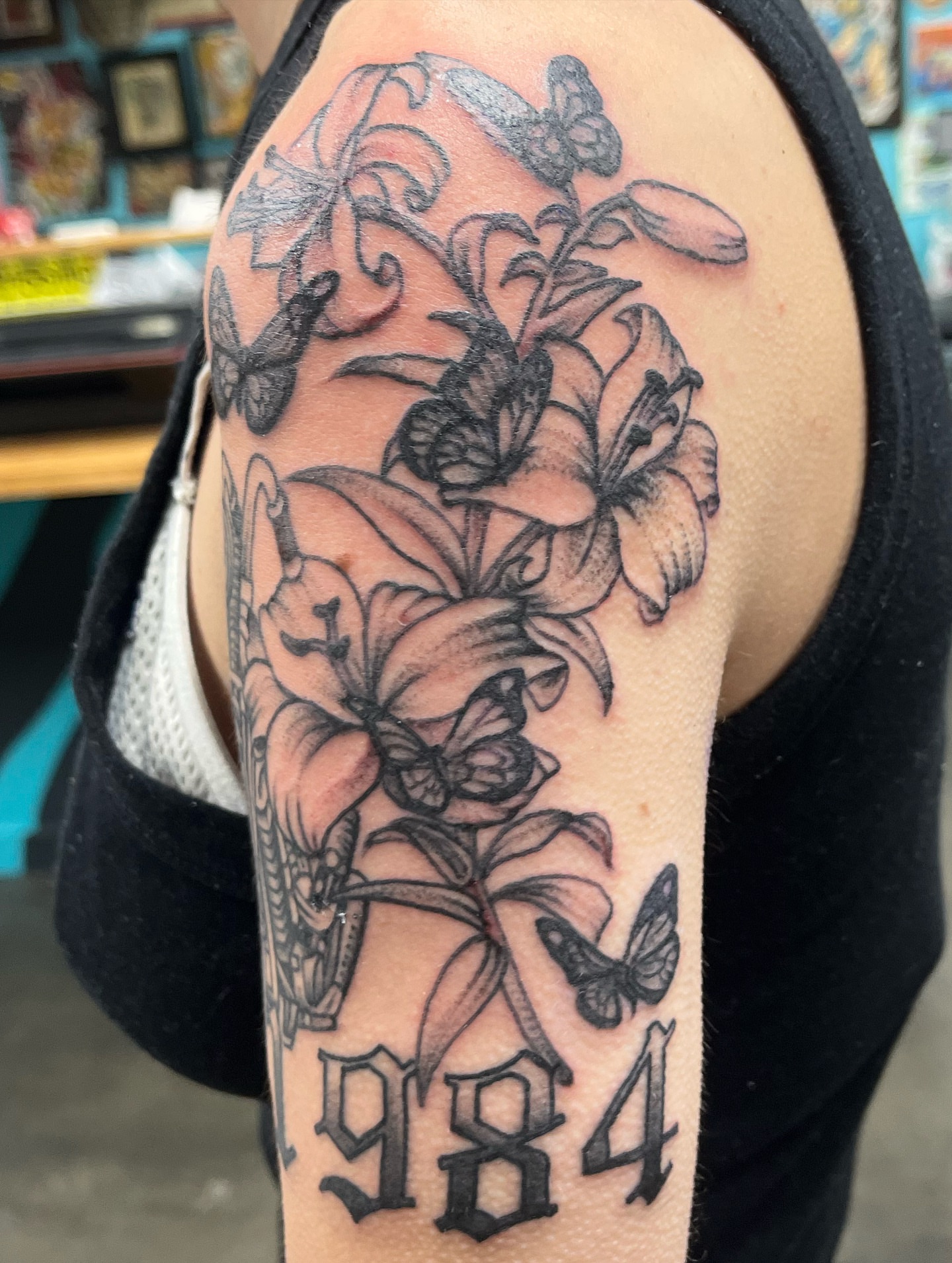 Lilies and butterflies realism tattoo on the forearm by Ashley Camp