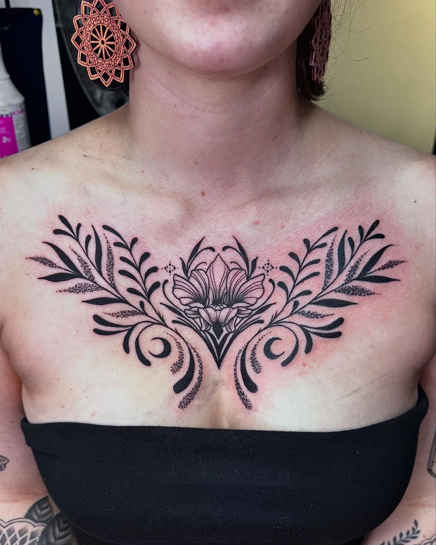 Floral design dotwork tattoo on the chest by Colby McClain