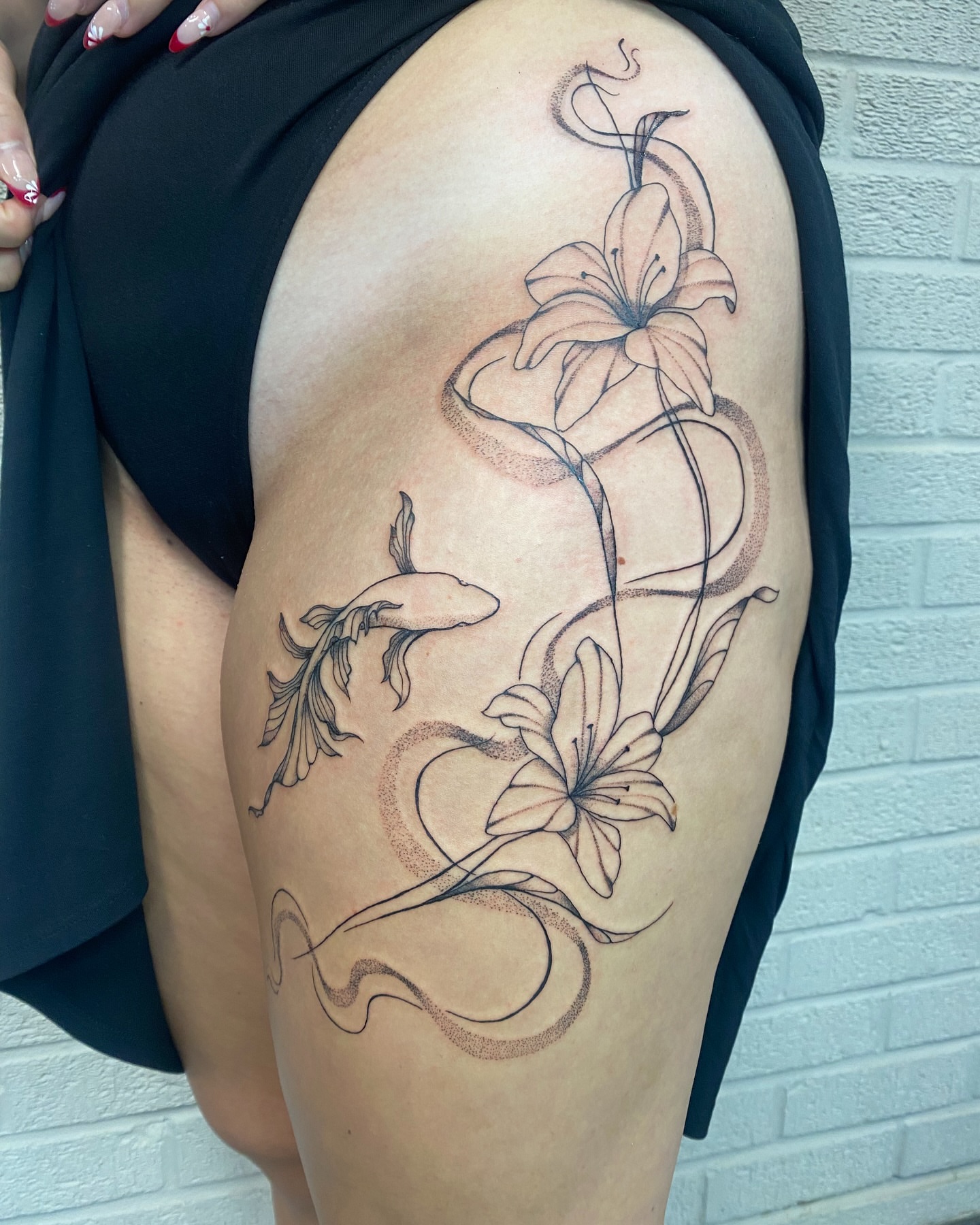 Lilies black and grey tattoo on the thigh by Ellena Reggiani