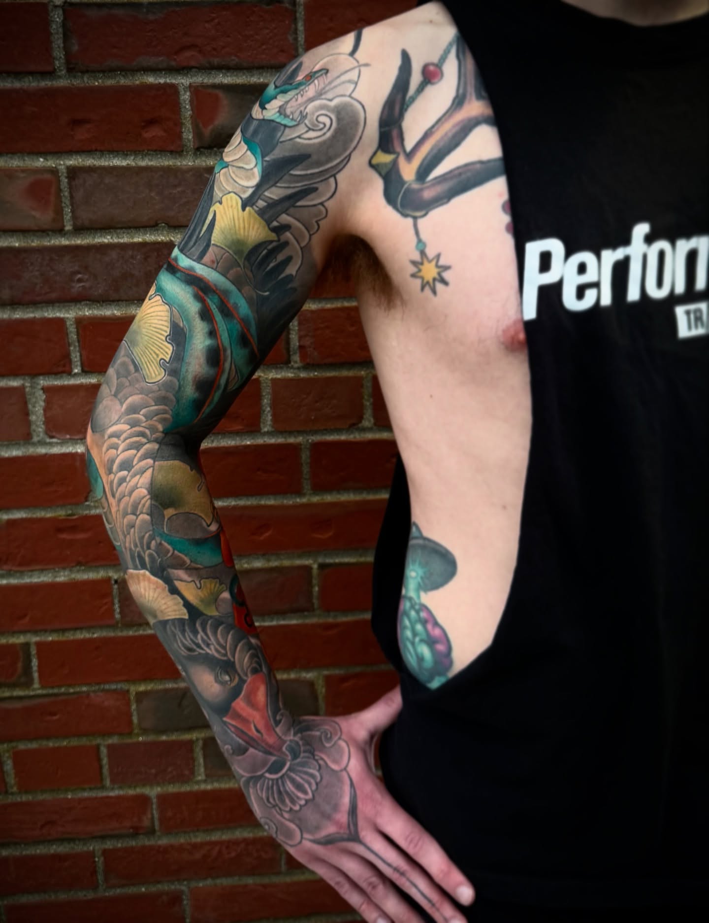 Koi fish and dragon American traditional tattoo on the upper arm by Jessica Brown
