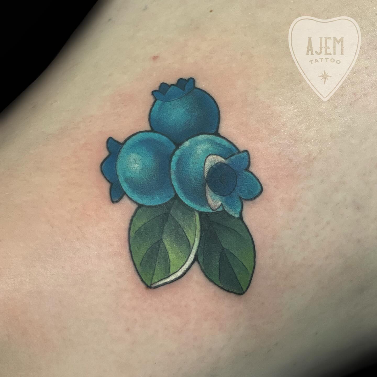 Blueberries realism tattoo on the thigh by Ash MacIsaac
