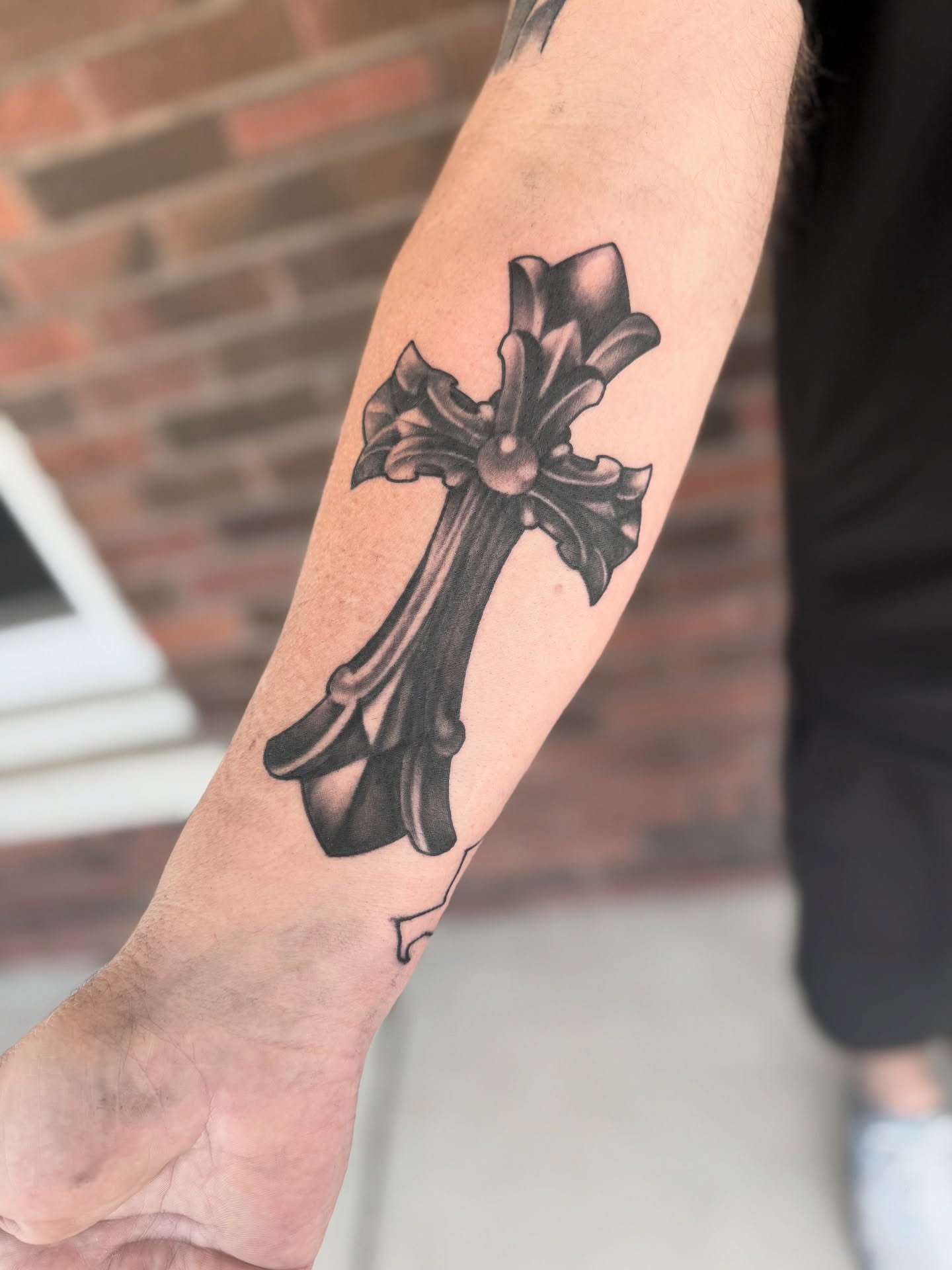 Cross black and grey tattoo on the forearm by Jeremy Utley