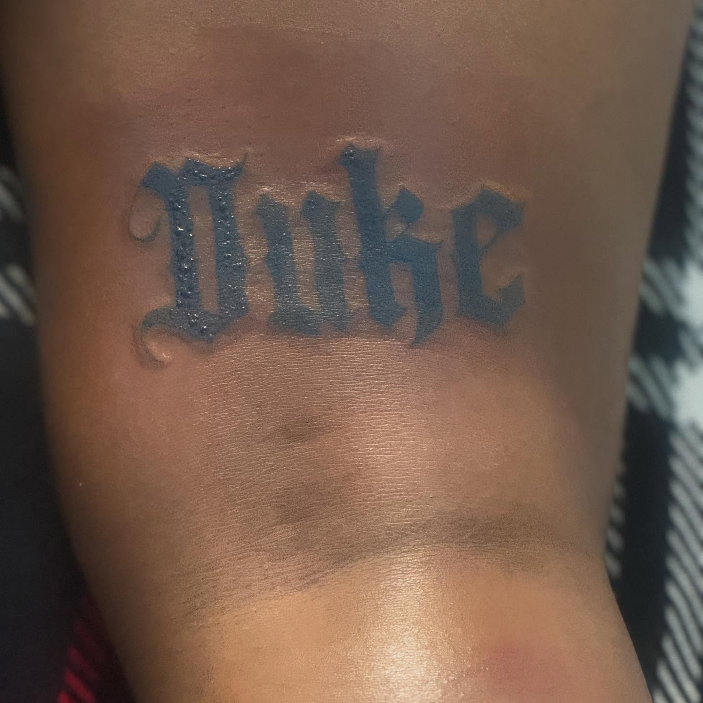 Duke lettering script tattoo on the forearm by Family and Loyalty