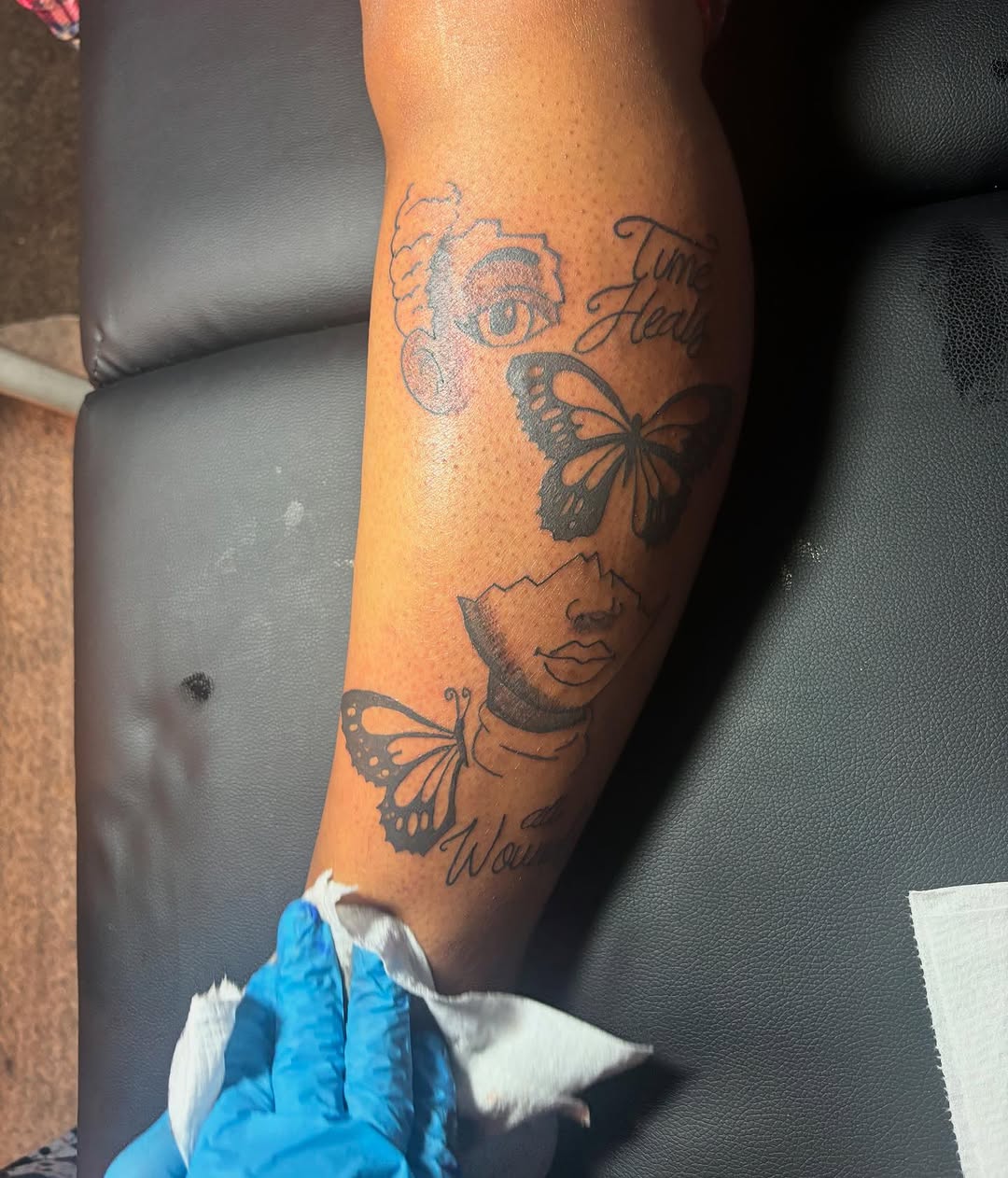 Face and butterflies with script surrealism tattoo on the forearm by Family and Loyalty