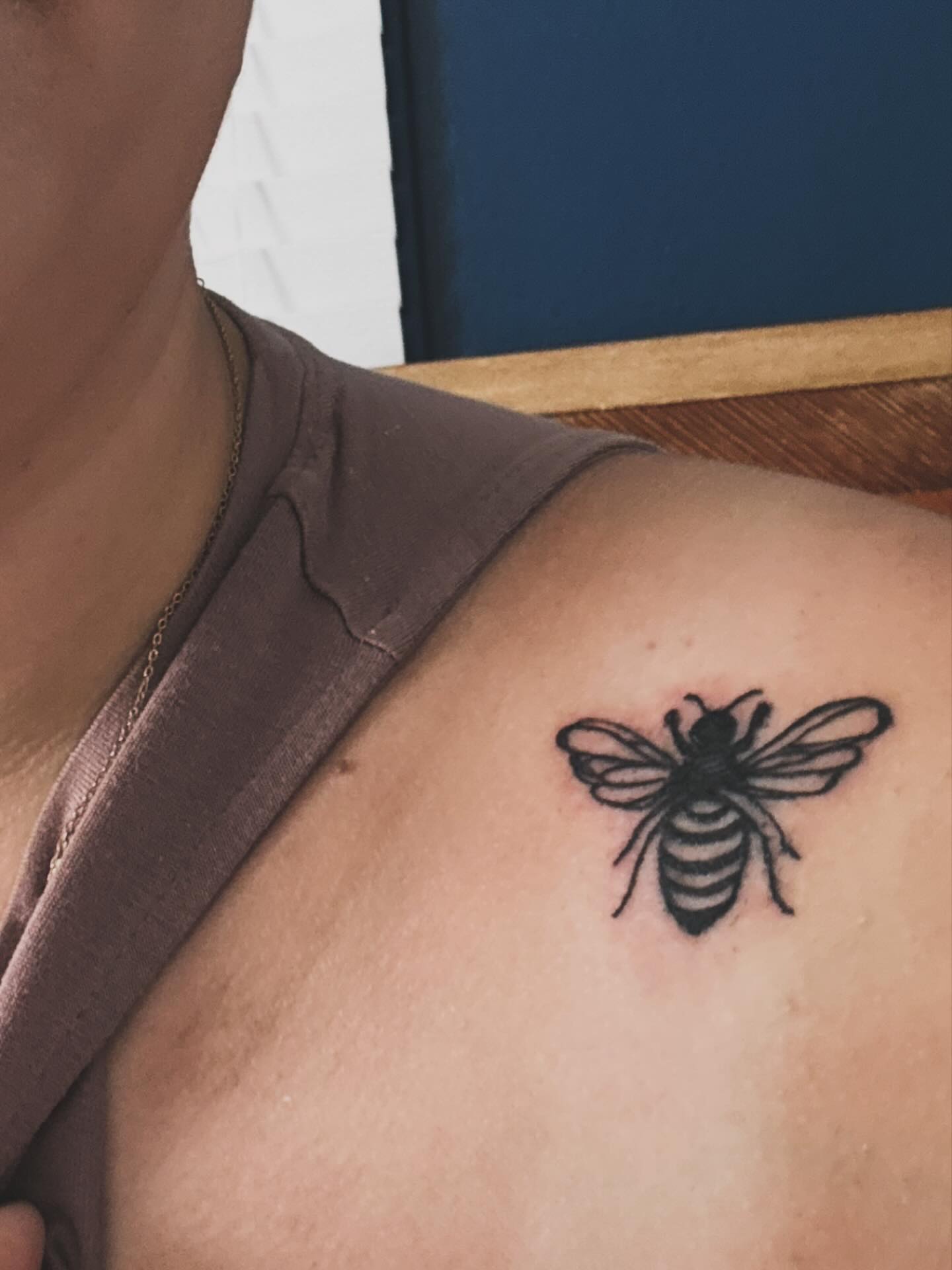 Bee black and grey tattoo on the shoulder by Victoria Cooper