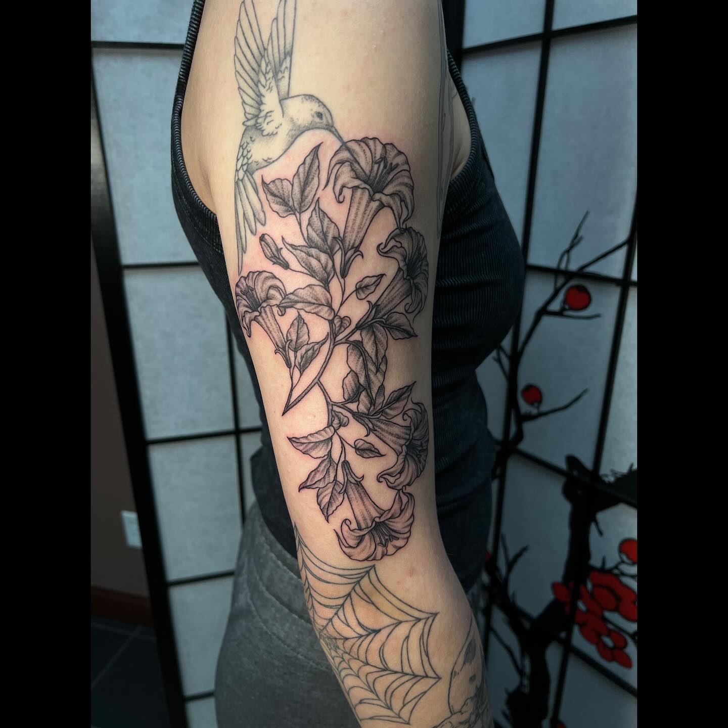 Bird and flowers black and grey tattoo on the forearm by Ali, Cedar Rapids, Iowa