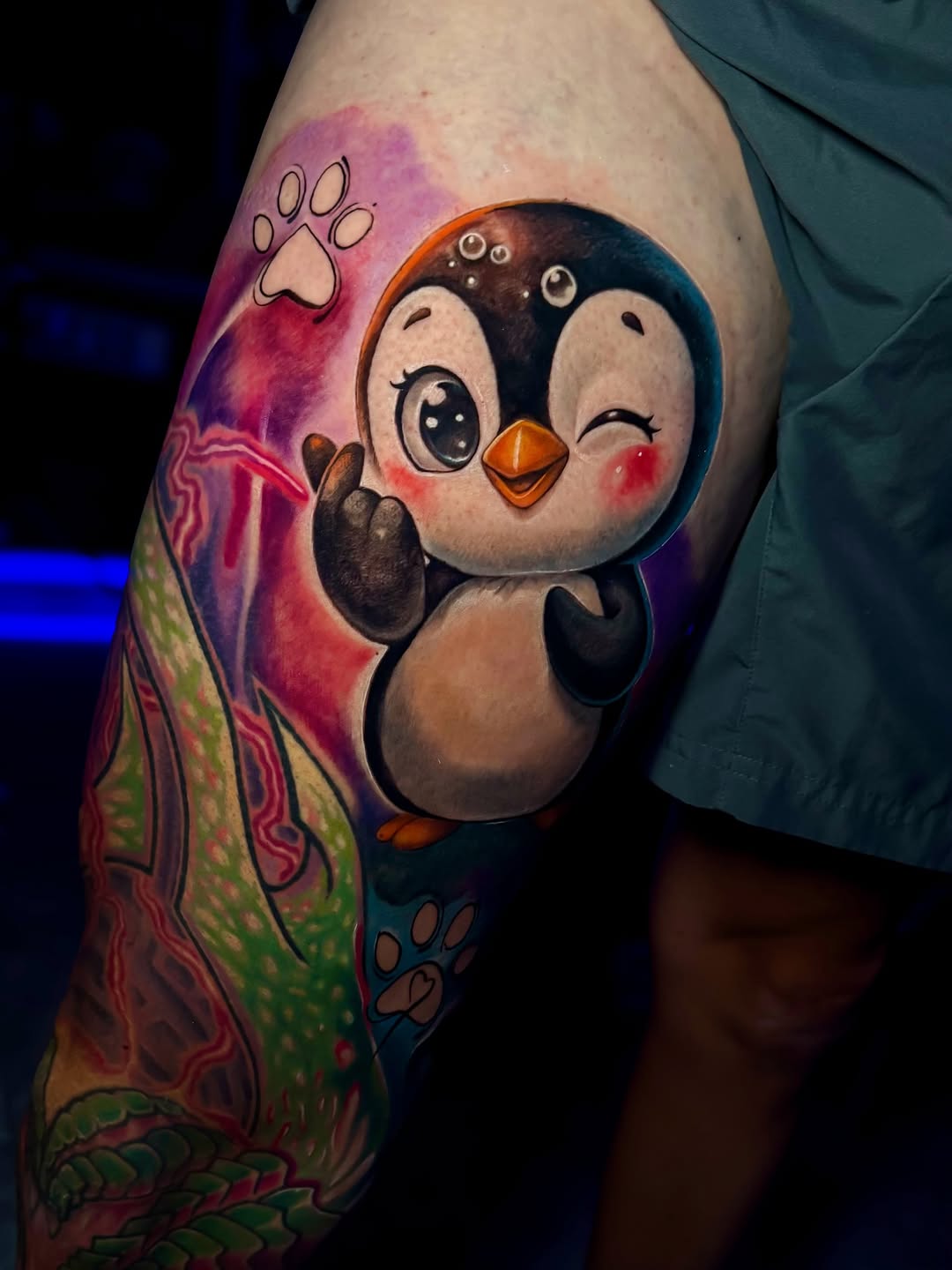 Cute penguin with paw prints new school tattoo on the thigh by Laurent Alba