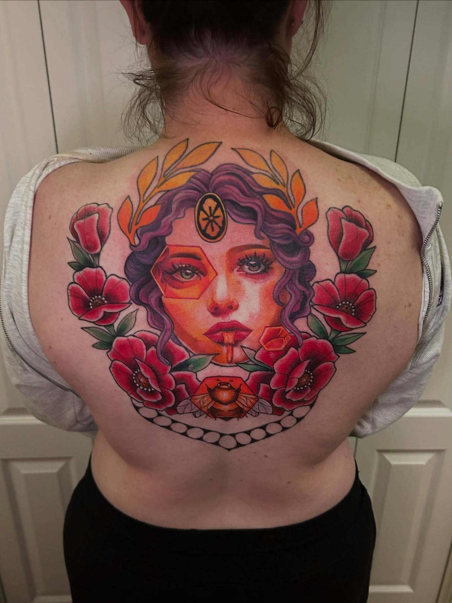 Woman with flowers American traditional tattoo on the back by Mando Castro