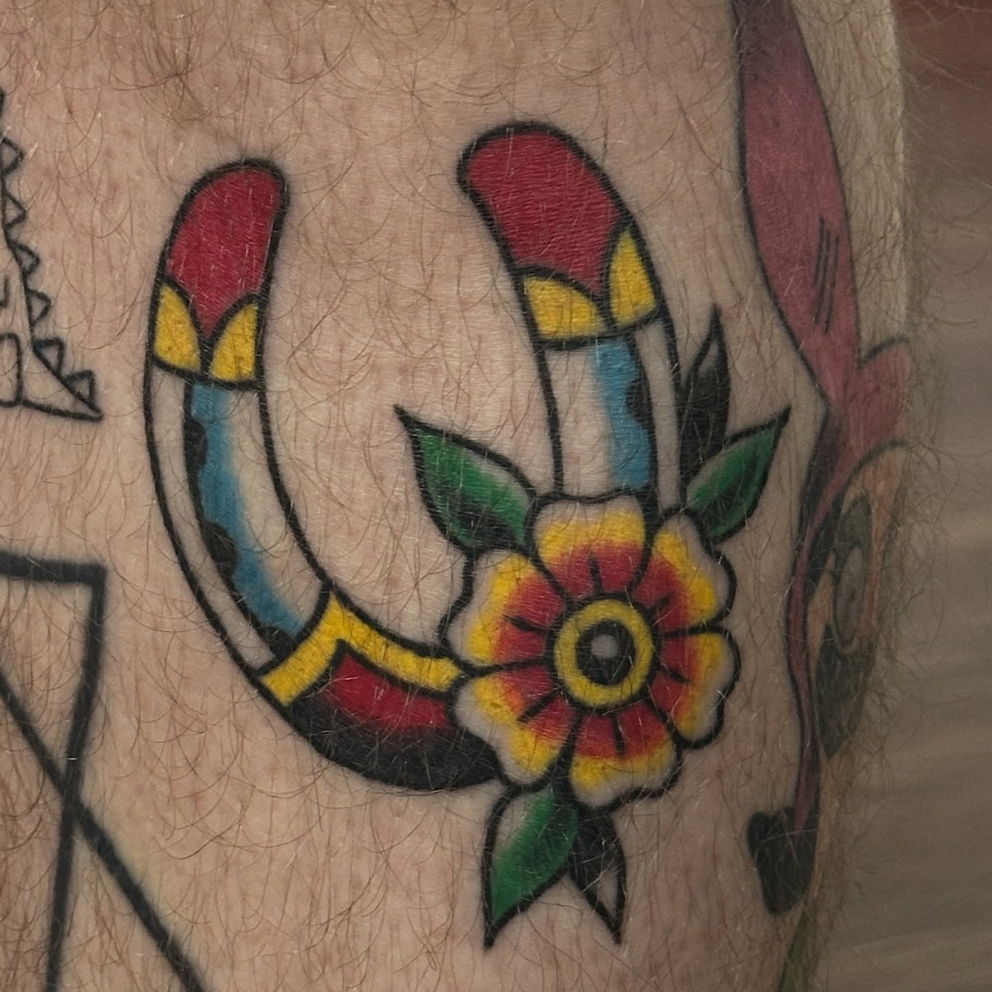 Horseshoe and flower American traditional tattoo on the forearm by julian solis, Houston, Texas