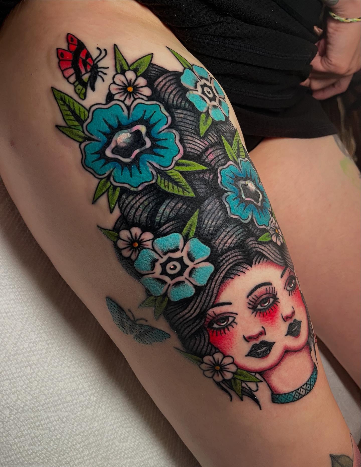 Geisha with flowers American traditional tattoo on the thigh by Marqui Watling