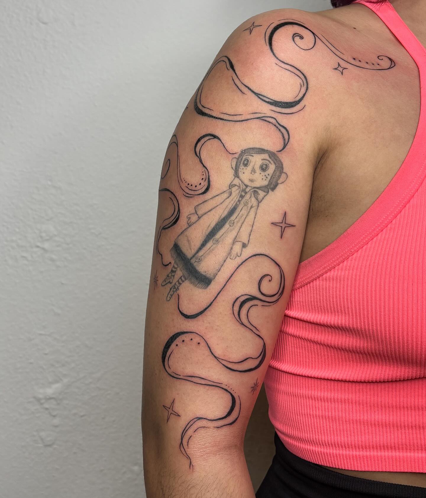 Doll with smoke black and grey tattoo on the upper arm by alyssa doing tattoos