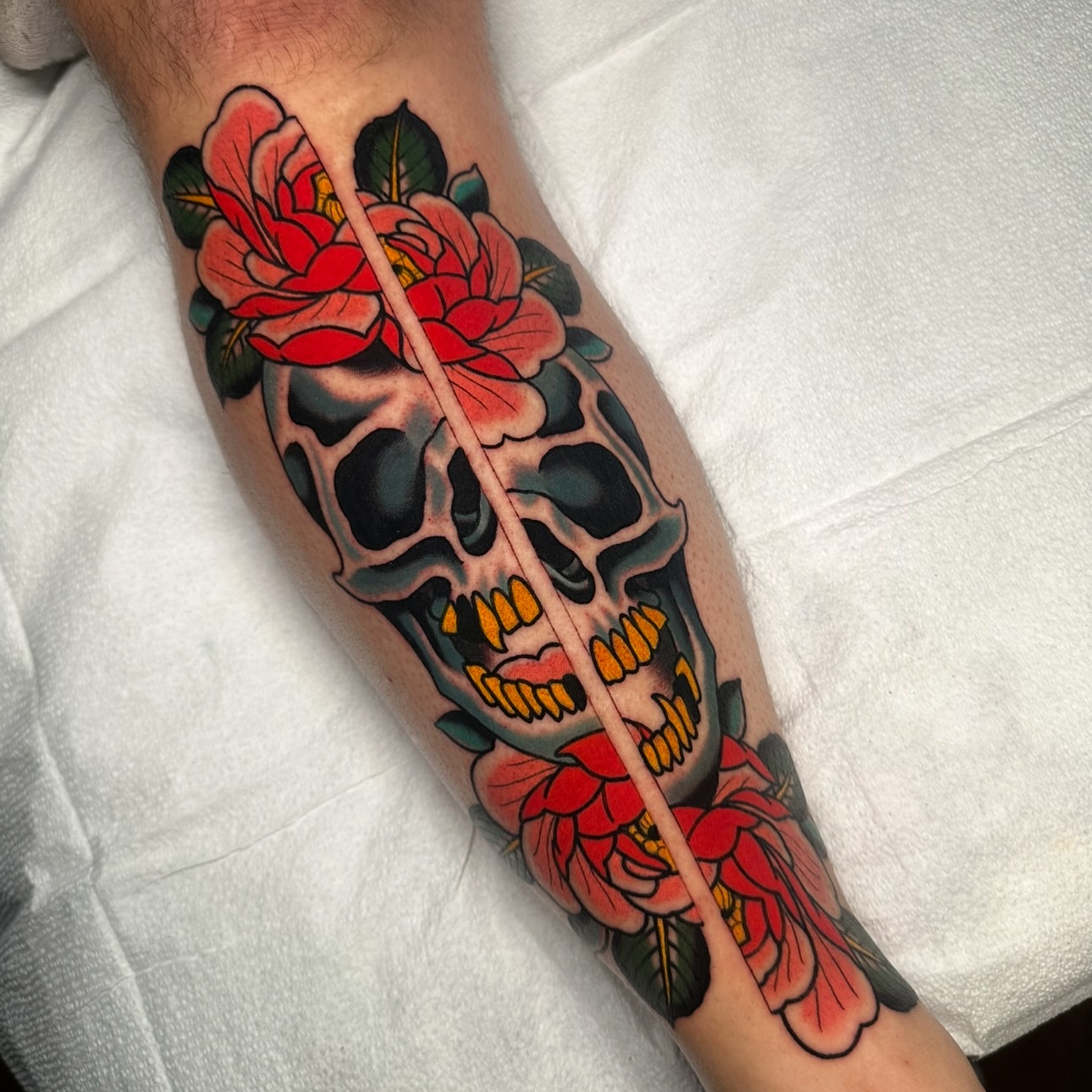 Skull with roses American traditional tattoo on the forearm by Schyler Ames, Canal Fulton, Ohio
