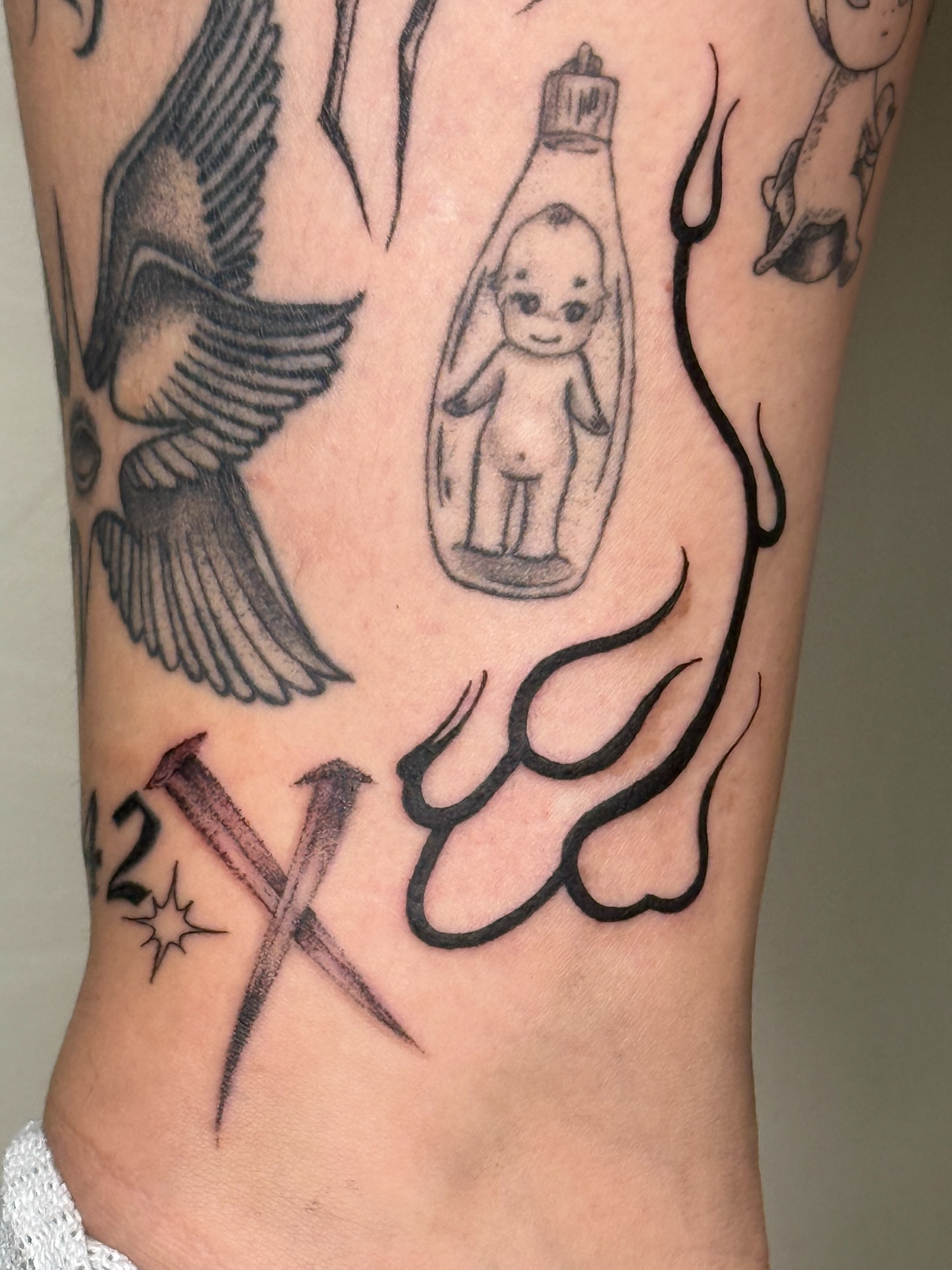 Baby doll in bottle black and grey tattoo on the forearm by šianca٠࣪ā