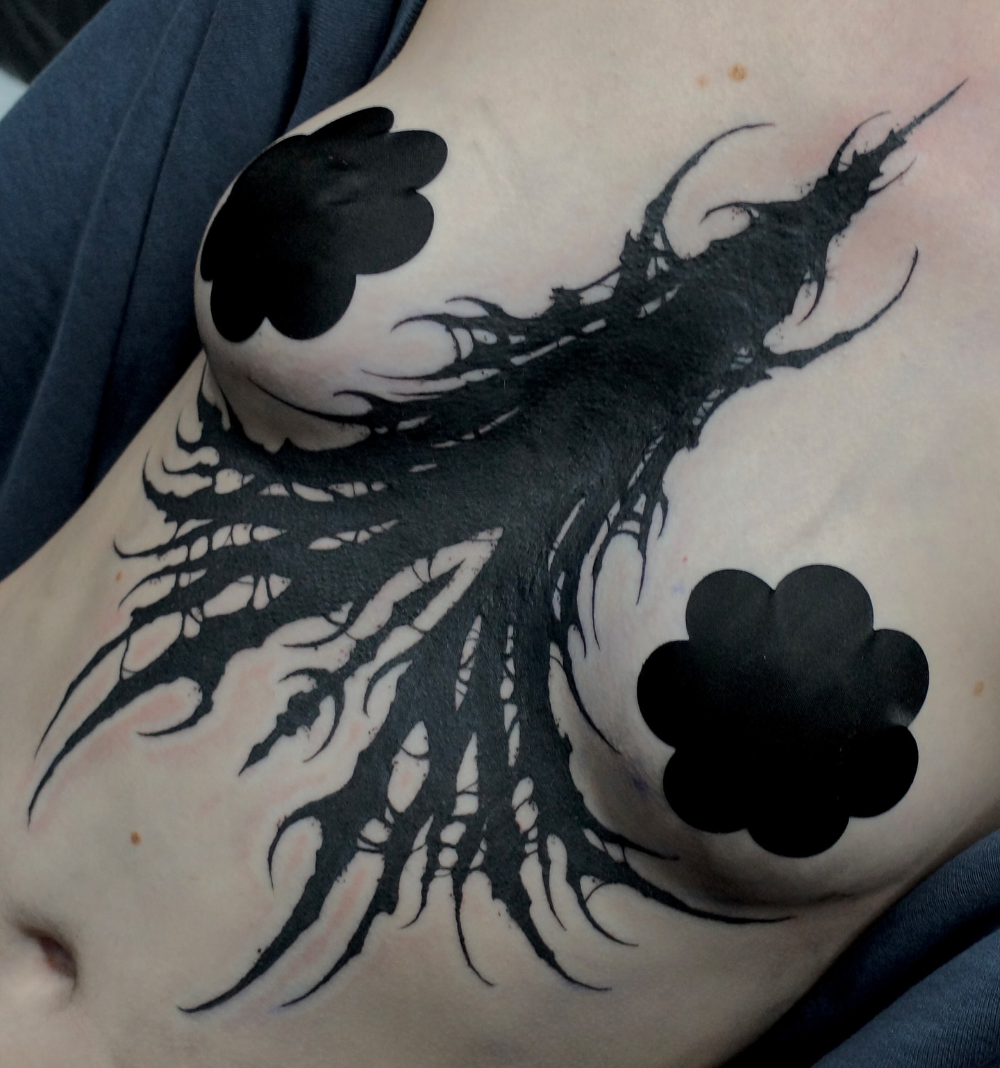 Abstract bird tribal tattoo on the chest by Jamie