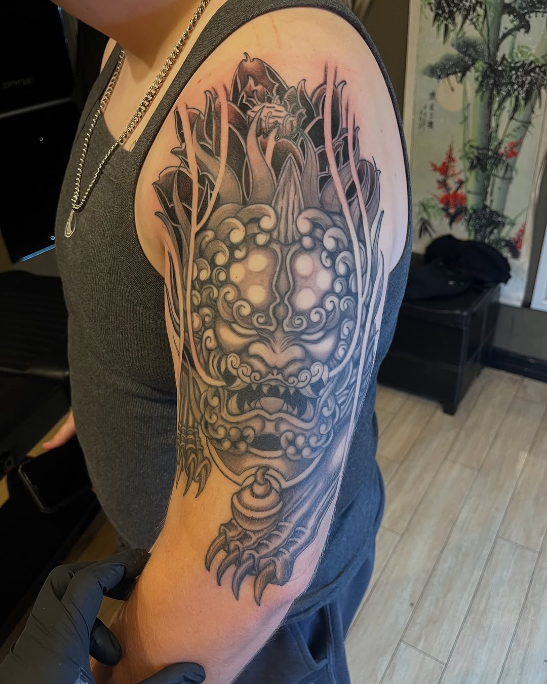 Foo dog Japanese tattoo on the upper arm by Winston Thai