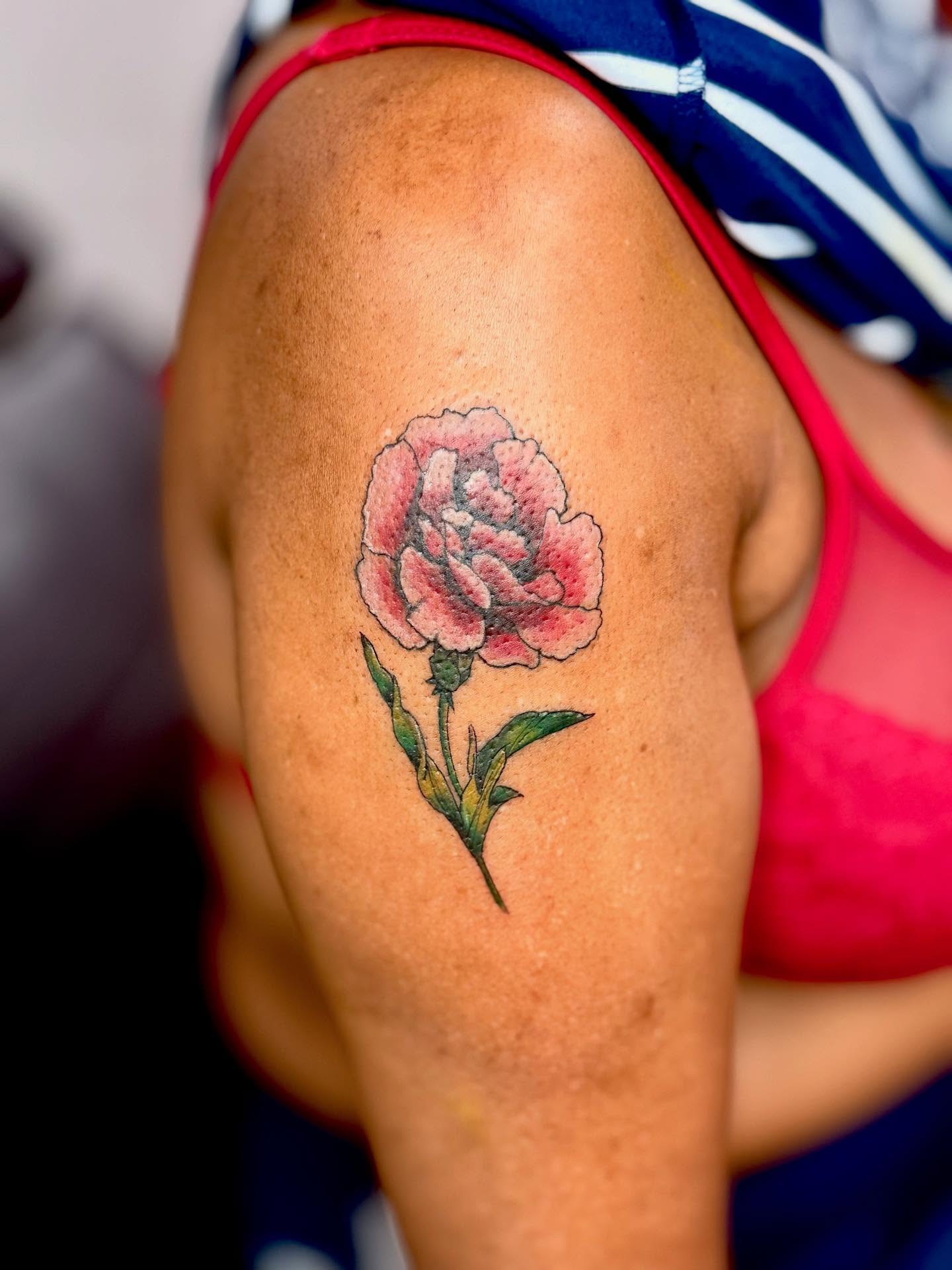 Carnation realism tattoo on the upper arm by dotMX