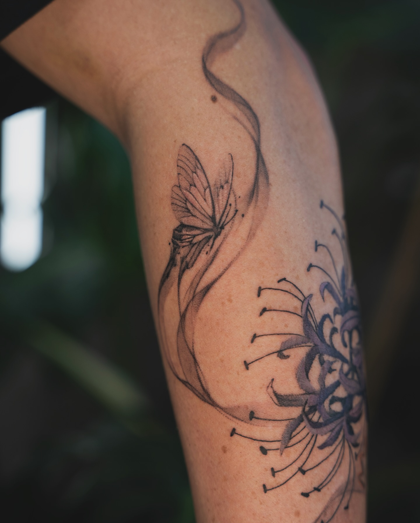 Butterfly and flower dotwork tattoo on the forearm by Tri