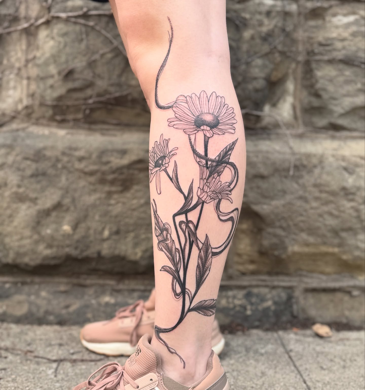 Daisies black and grey tattoo on the calf by Sydney