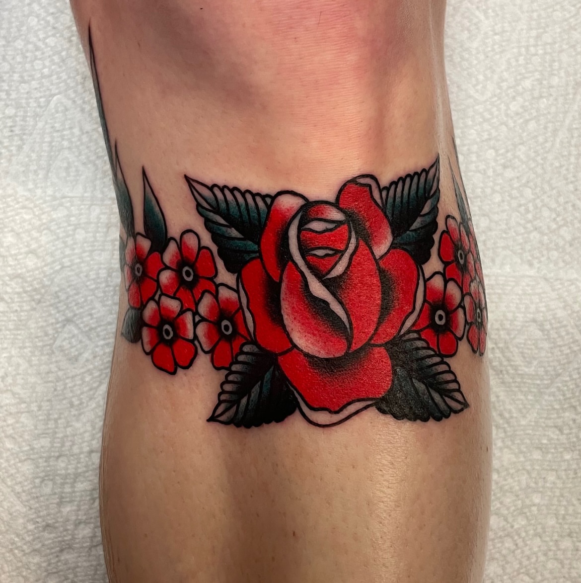 Red rose American traditional tattoo on the forearm by Texas Jonah