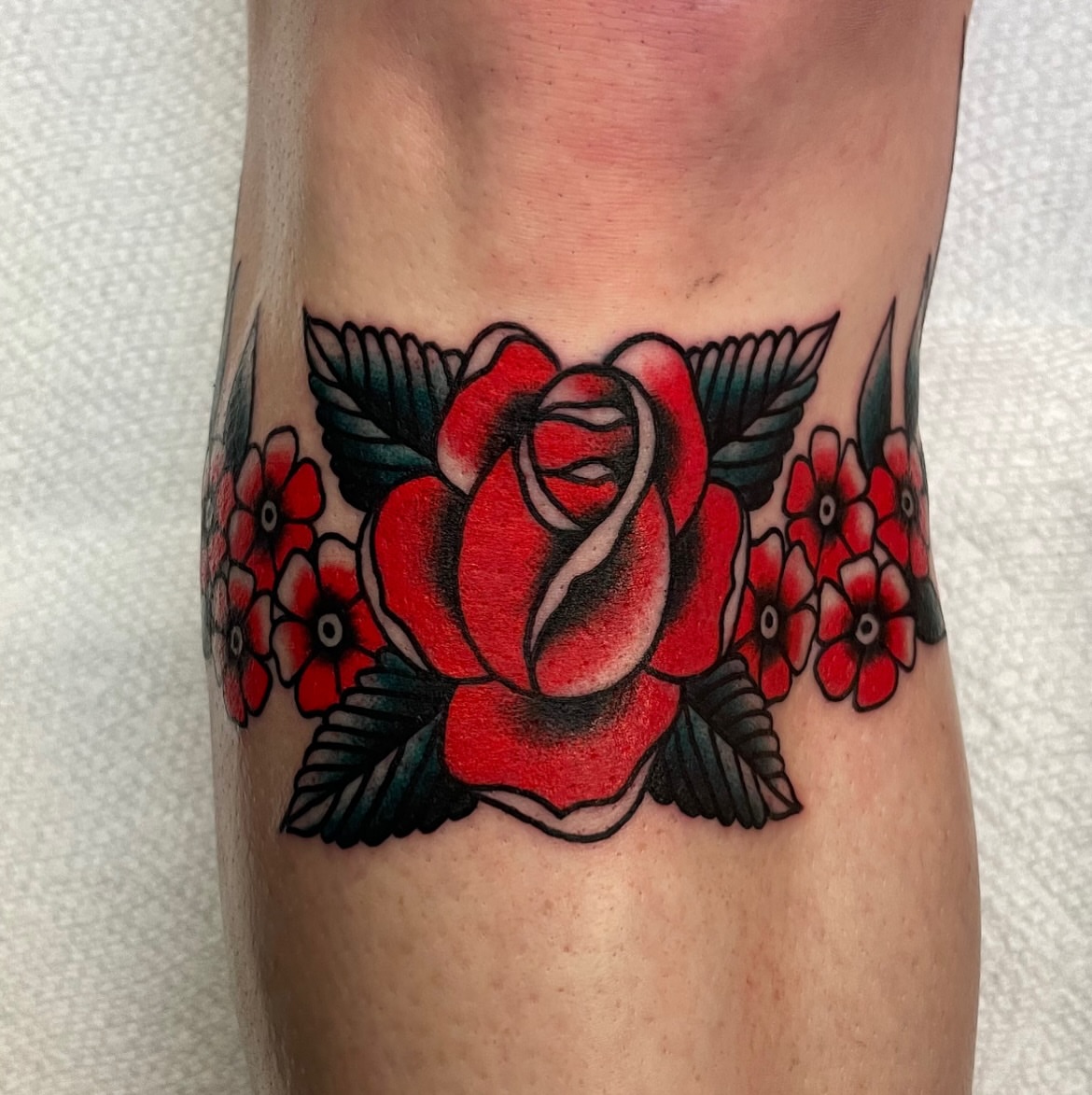 Red rose American traditional tattoo on the forearm by Texas Jonah