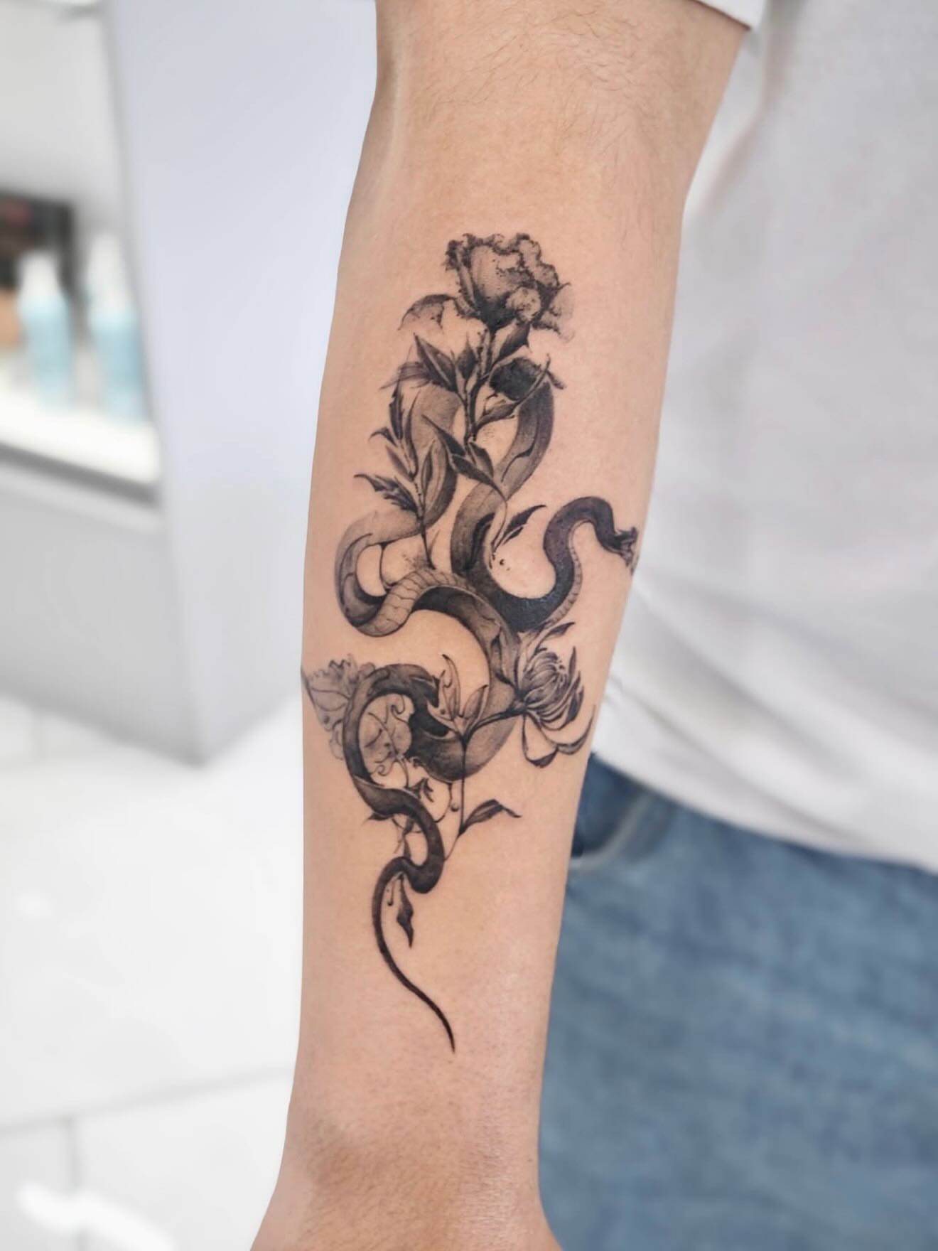 Snake and rose realism tattoo on the forearm by MJ tattooist
