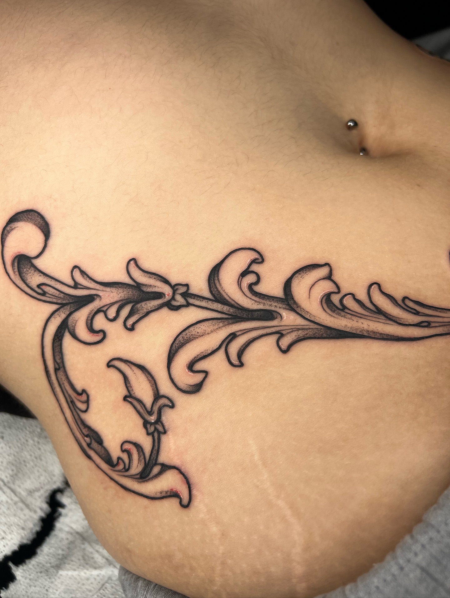 Scrollwork ornamental tattoo on the ribs by 𝔐𝔦𝔠𝔥𝔢𝔩𝔩𝔢 ℭ𝔥𝔞𝔪𝔢𝔯𝔩𝔦𝔨