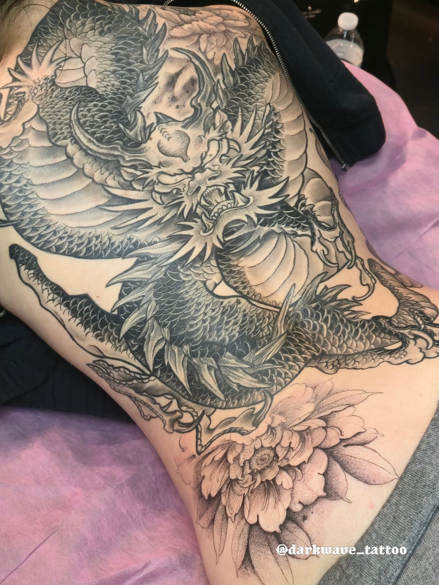 Dragon and peony realism tattoo on the thigh by Barrett Handel