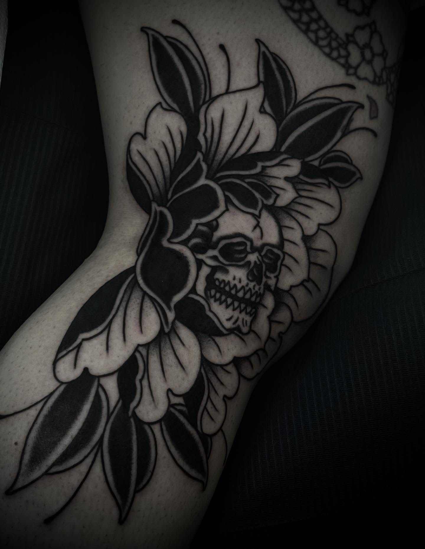 Skull and flowers black and grey tattoo on the forearm by Ally noel