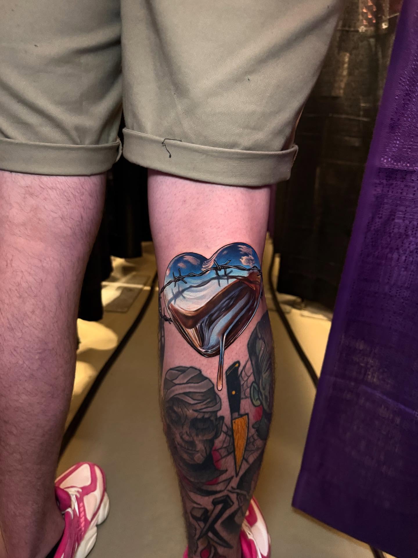 Heart with barbed wire neo-traditional tattoo on the calf by Derek Gardner