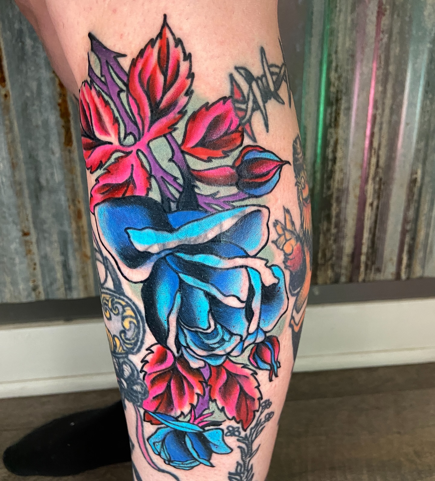 Blue and red roses American traditional tattoo on the calf by Quinn