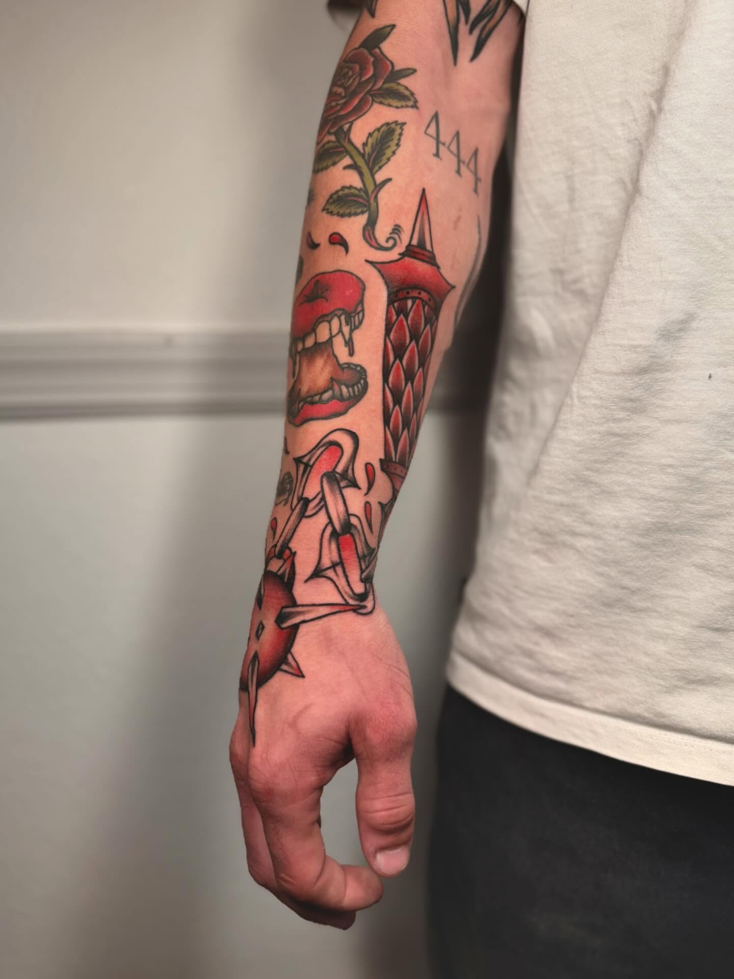 Red rose and skull American traditional tattoo on the forearm by laura baldwin