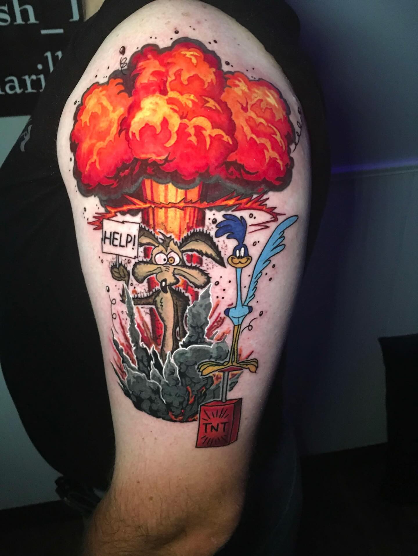 Cartoon characters under explosion illustrative tattoo on the forearm by Joshua Shawn