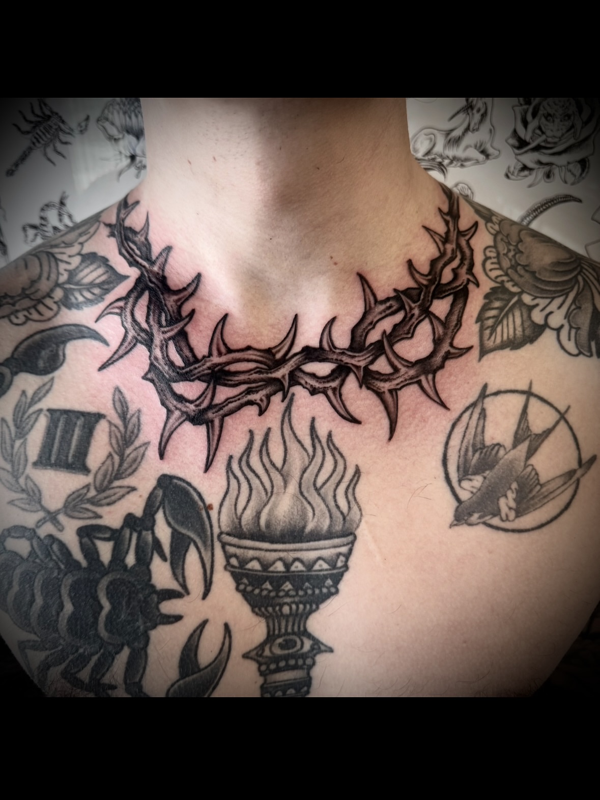 Torch and crown black and grey tattoo on the chest by Kristen
