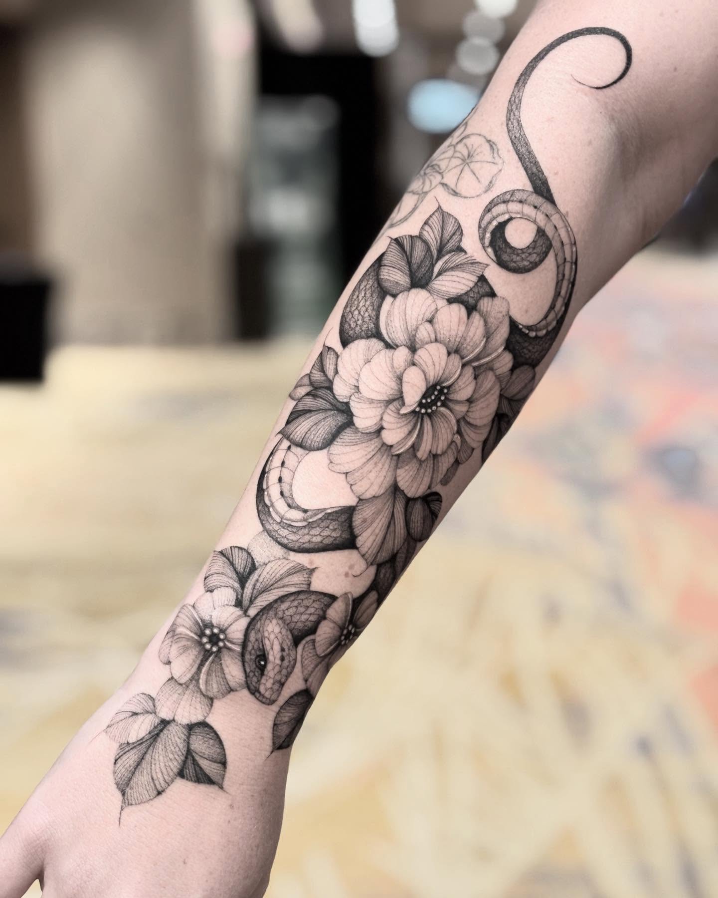 Flowers and snake black and grey tattoo on the forearm by Brittney Naami, San Francisco, California